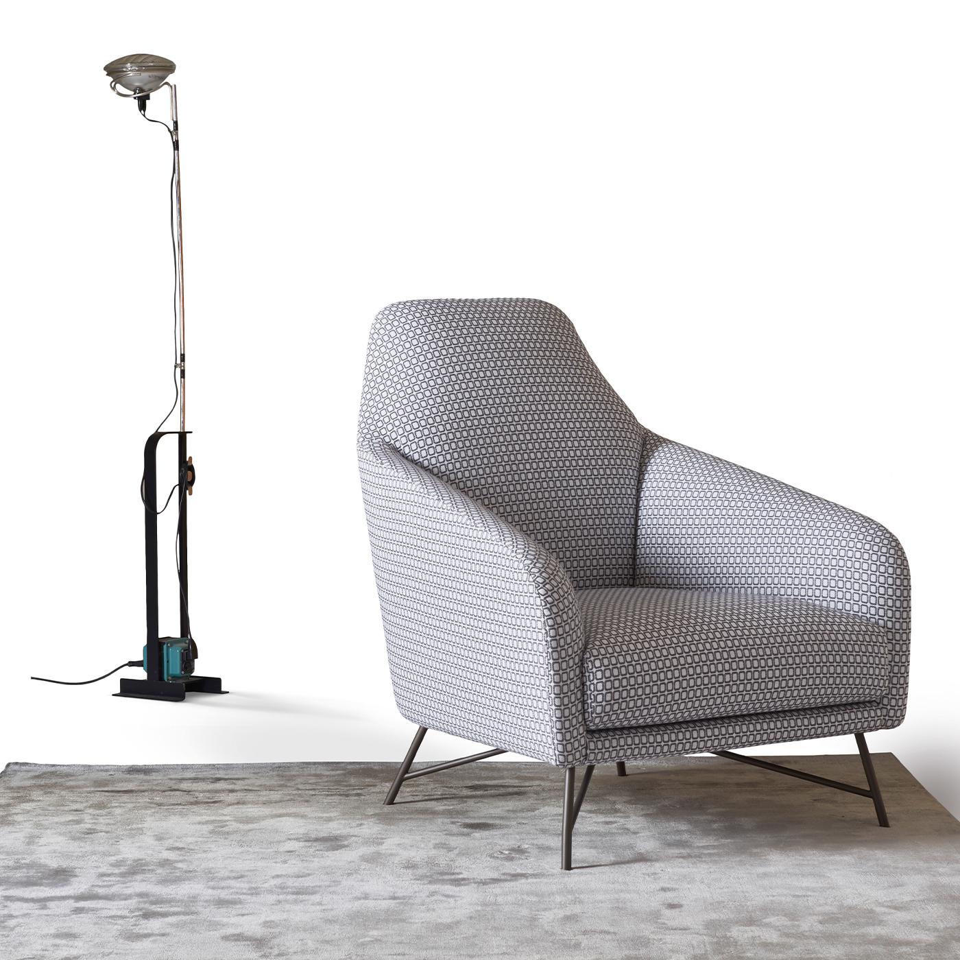 Inspired by the extravagant shapes of the 1950s, this singular armchair by Angeletti Ruzza will make a sophisticated statement in any modern decor. Made of gunmetal-lacquered metal, the four slanted legs feature a thin, tubular profile juxtaposed to