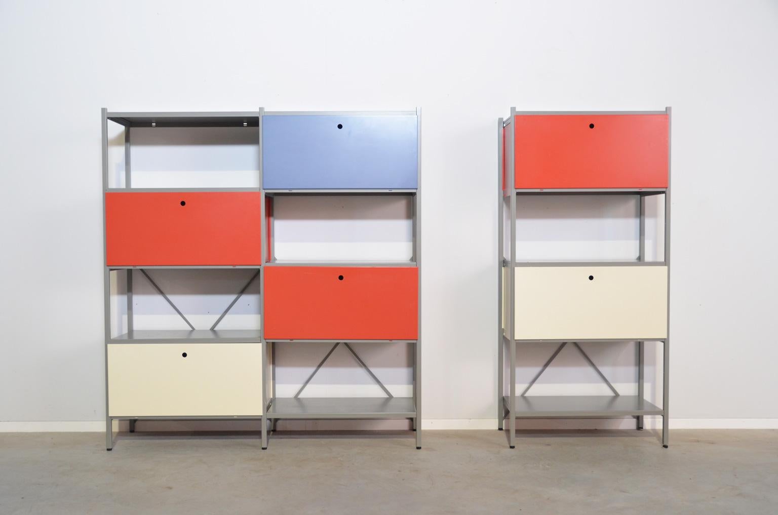 Industrial modular wall system by Wim Rietveld for Gispen originally designed in 1954. These units are a re-edition dated 1990s. Two units, one with four closed cabinets (blue, red and white) and the other one with two closed cabinets (white and