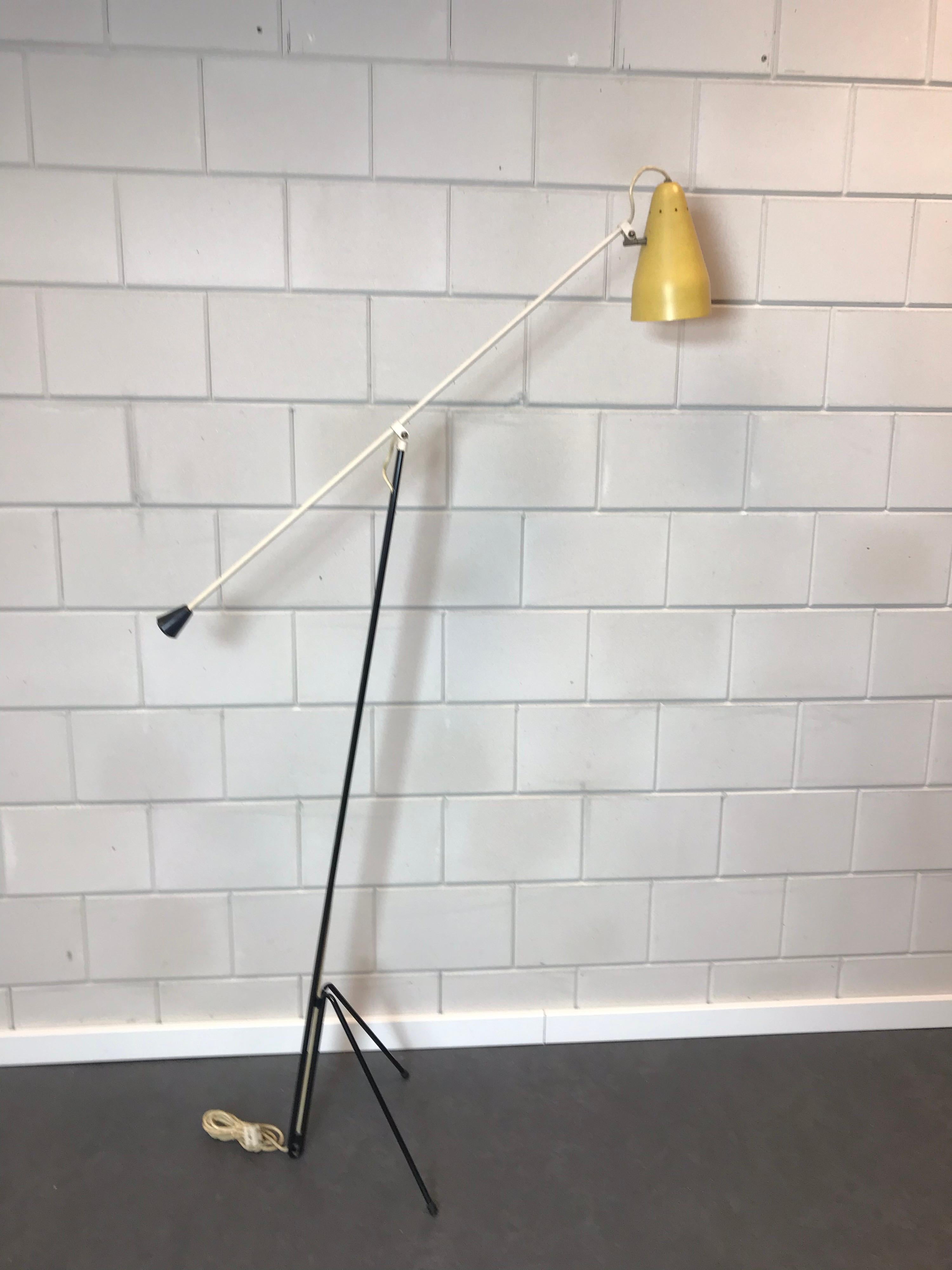 Rare lampadaire dit numéro 6320 conçu par Wim Rietveld pour la société néerlandaise Gispen.
Conçue en 1953, elle est toujours d'actualité.
Lampe sur pied tripode en métal noir avec bras réglable blanc et capot d'origine laqué jaune avec des trous