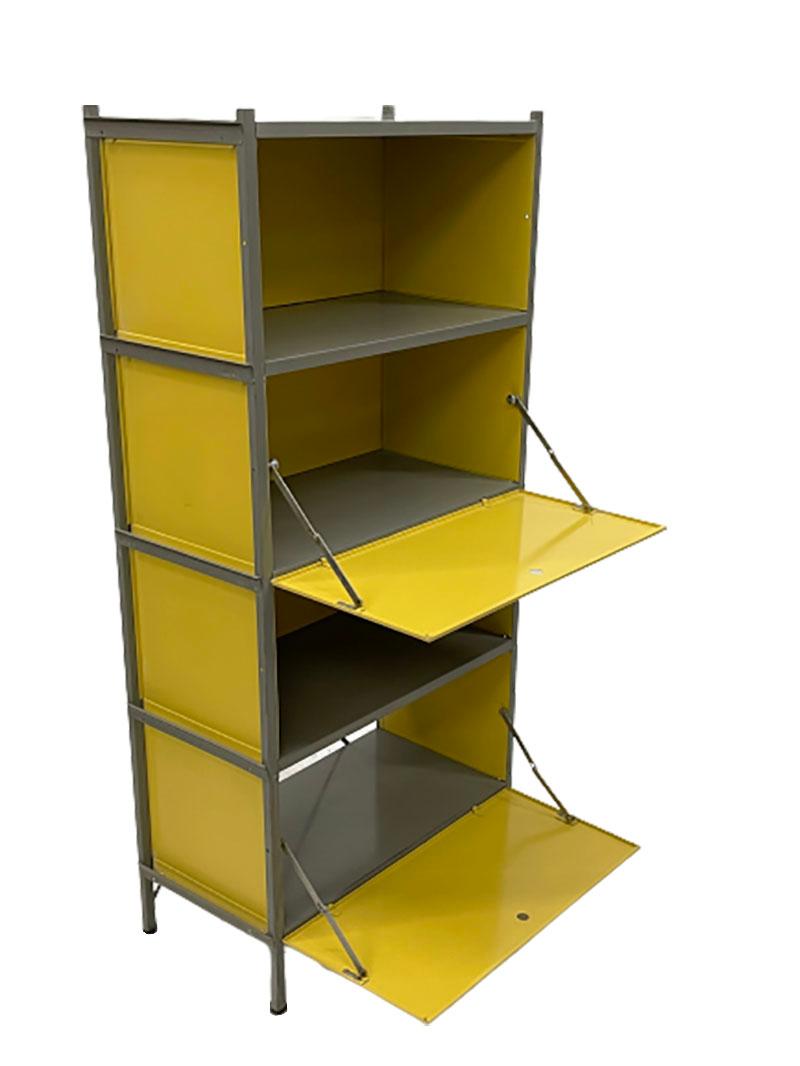 Wim Rietveld modular wall cabinet.

A yellow with gray lacquered metal wall cabinet.
The doors of the cabinet, with round holes to open them.
This cabinet has 2 doors hinged downwards. Closed sides and back wall in the 3 top