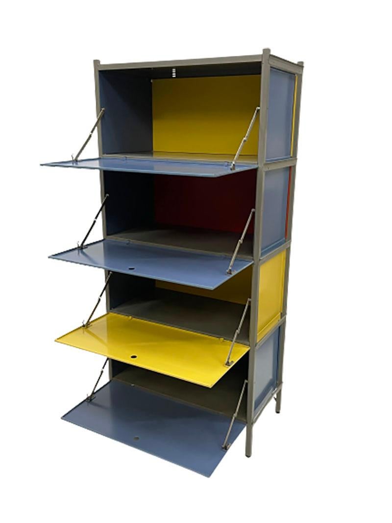 Wim Rietveld modular wall cabinet.

A yellow with gray lacquered metal wall cabinet.
The doors of the cabinet, with round holes to open them.
This cabinet has 4 doors hinged downwards. Closed sides and back wall in the compartments.
The 2 top