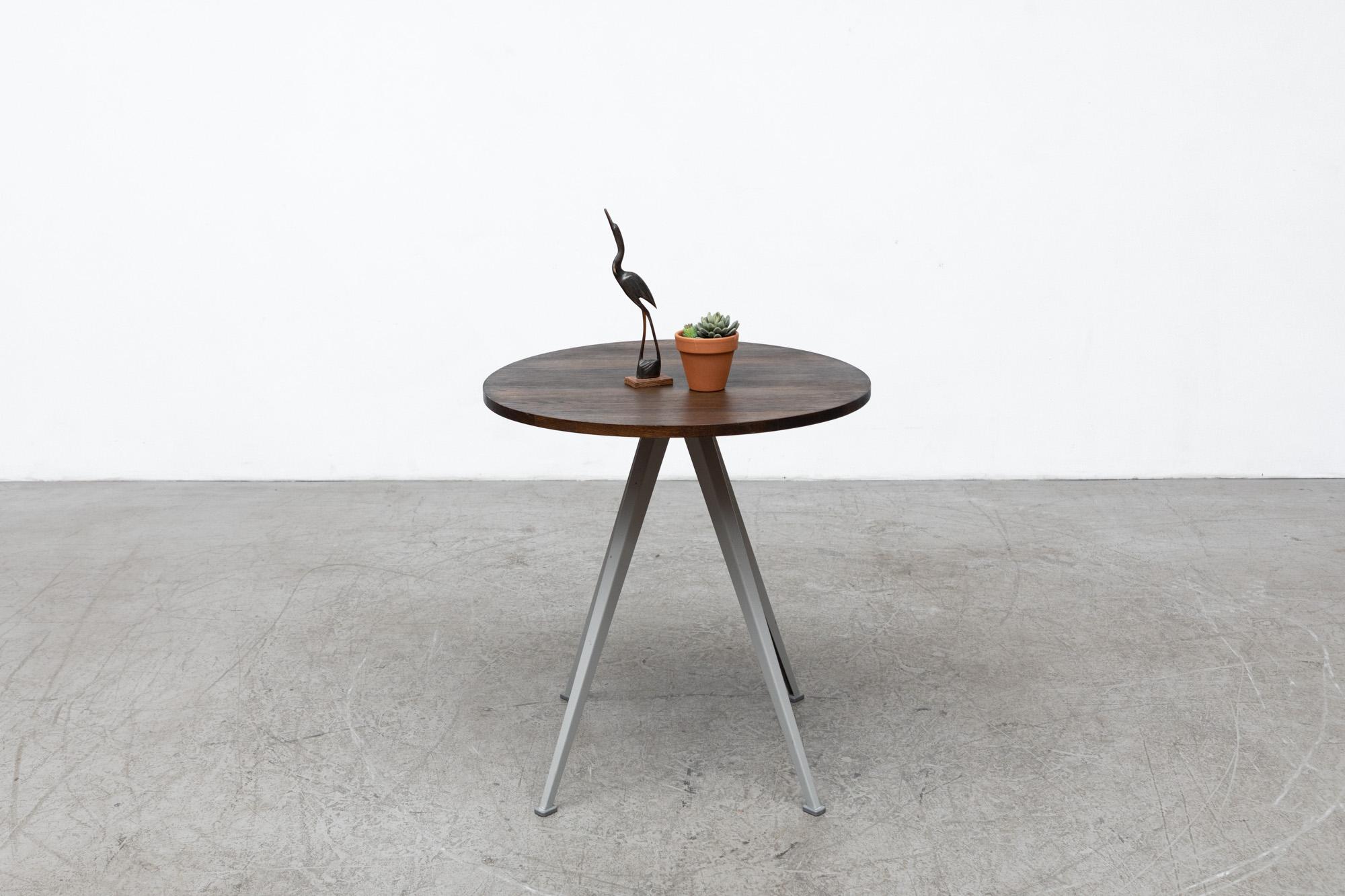 Side table with round smoked oak wood top and grey enameled metal pyramid legs designed by Friso Kramer and Wim Rietveld for Ahrend in the 1950s and reissued in 2015 by Hay. In original condition, with minimal wear that is consistent with age and