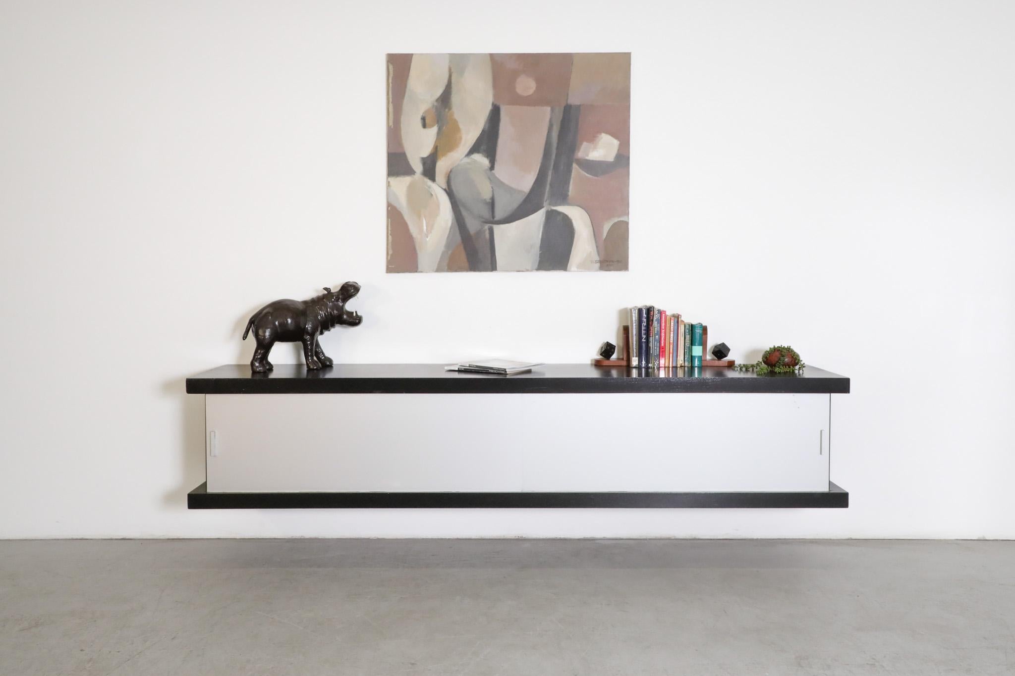 Model 'D242' floating credenza designed by Wim Wilson for Castelijn, 1964. Black lacquered wood frame with gray aluminum sliding doors and oak interior. A cool and sleek floating storage cabinet with natural wood and sophisticated style! In original