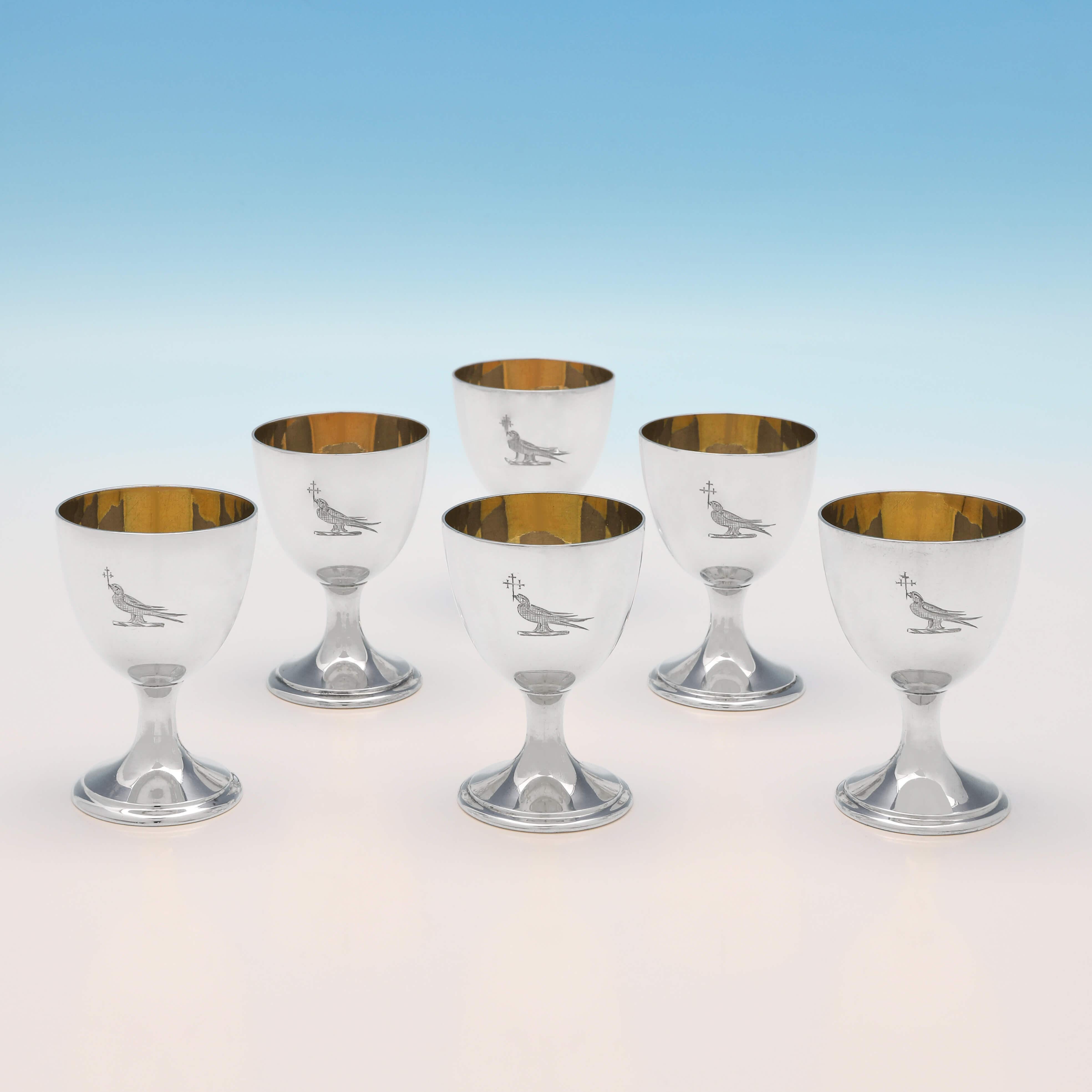 Hallmarked in London in 1884 by Barnards, this handsome, set of six, Victorian, antique sterling silver egg cups, are plain in style, featuring gilt interiors and an engraved crest. Each egg cup measures 2.5