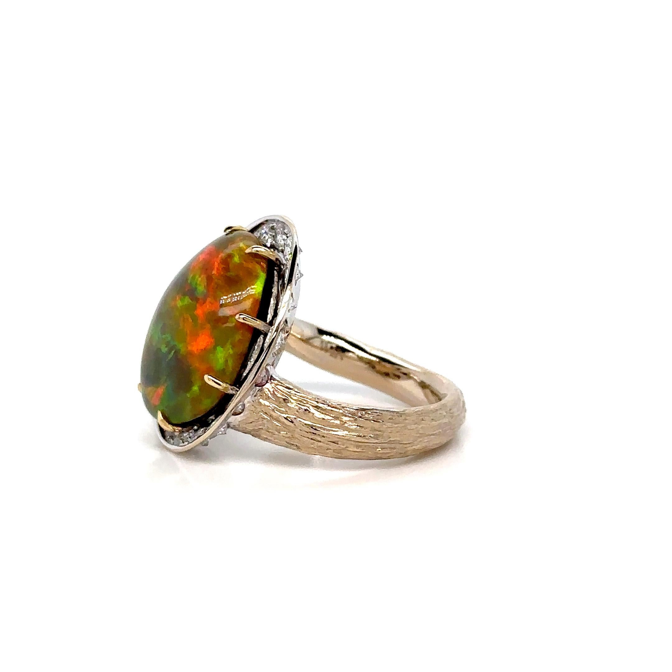 Ring aus 18 Karat Gold mit einem atemberaubenden Opal im Cabochon-Schliff von etwa 6,32 Karat. Der Opal zeigt ein auffälliges Farbspiel mit magischer Wirkung, das durch Diamanten im Brillantschliff von insgesamt rund 0,55 Karat ergänzt wird. Dieses