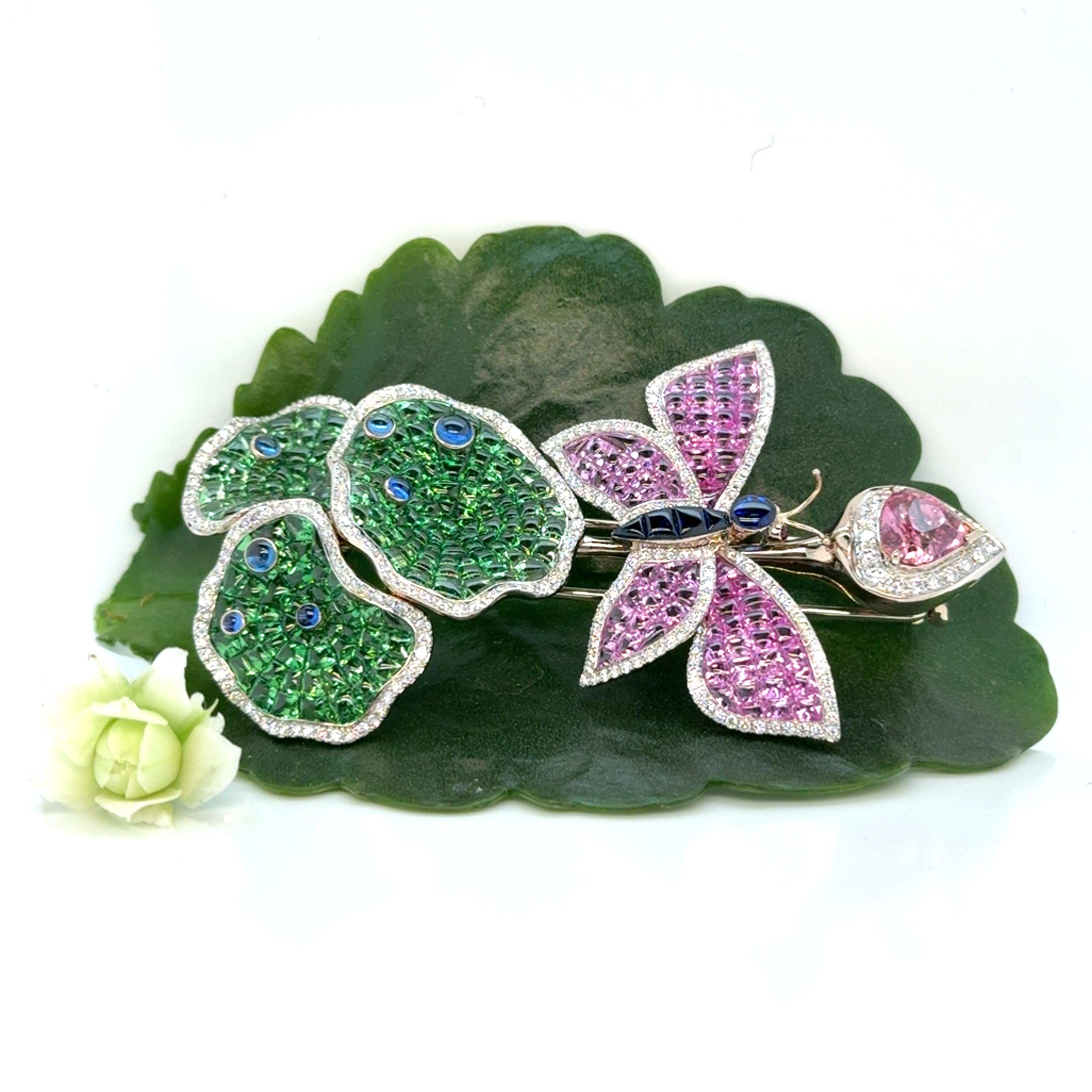 Gold brooch 18K, designed as a lotus bud, embraced by water lily leaves and a butterfly. The lotus bud is adorned with a natural drop-shaped padparadscha sapphire from Sri Lanka, weighing 2.53 carats. The water lily leaves are set with fancy-cut