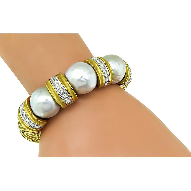 This is an amazing 18k yellow and white gold bangle by Winc. The bangle is set with lovely mabe pearls. The pearls are accentuated by sparkling round cut diamonds that weigh approximately 1.75ct. The color of the diamonds is H with VS clarity. The