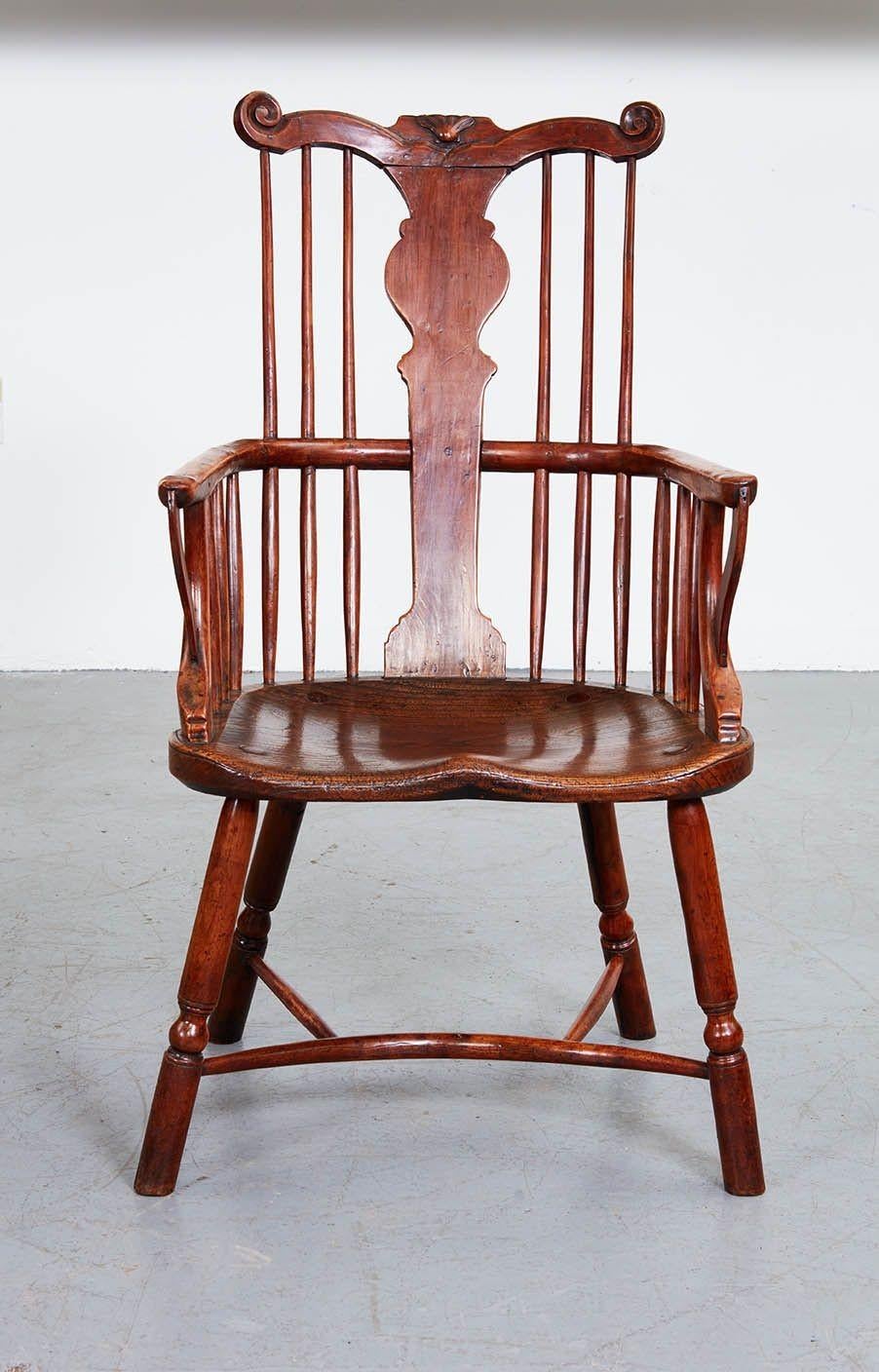 A fine windsor armchair with high comb back incorporating top rail with shell and scrolled ear ends, central shaped vasiform splat over continuous bent arm with forward arm supports, on saddled seat, standing on turned legs joined by crenoline