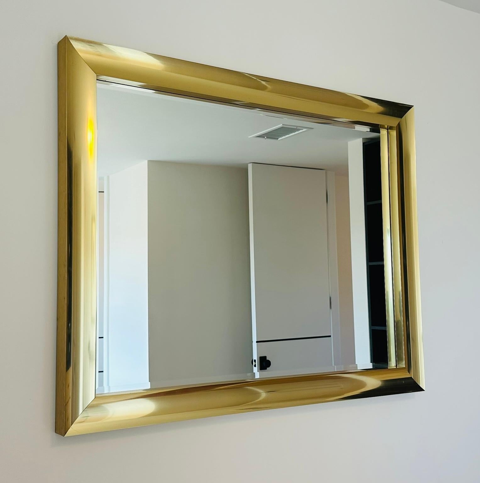 Elegante e sostanzioso specchio da parete vintage in alluminio ottonato di Windsor Art, realizzato negli Stati Uniti negli anni '80 circa. Questo specchio rettangolare di grande effetto è caratterizzato da una cornice dal profilo largo e audace, con