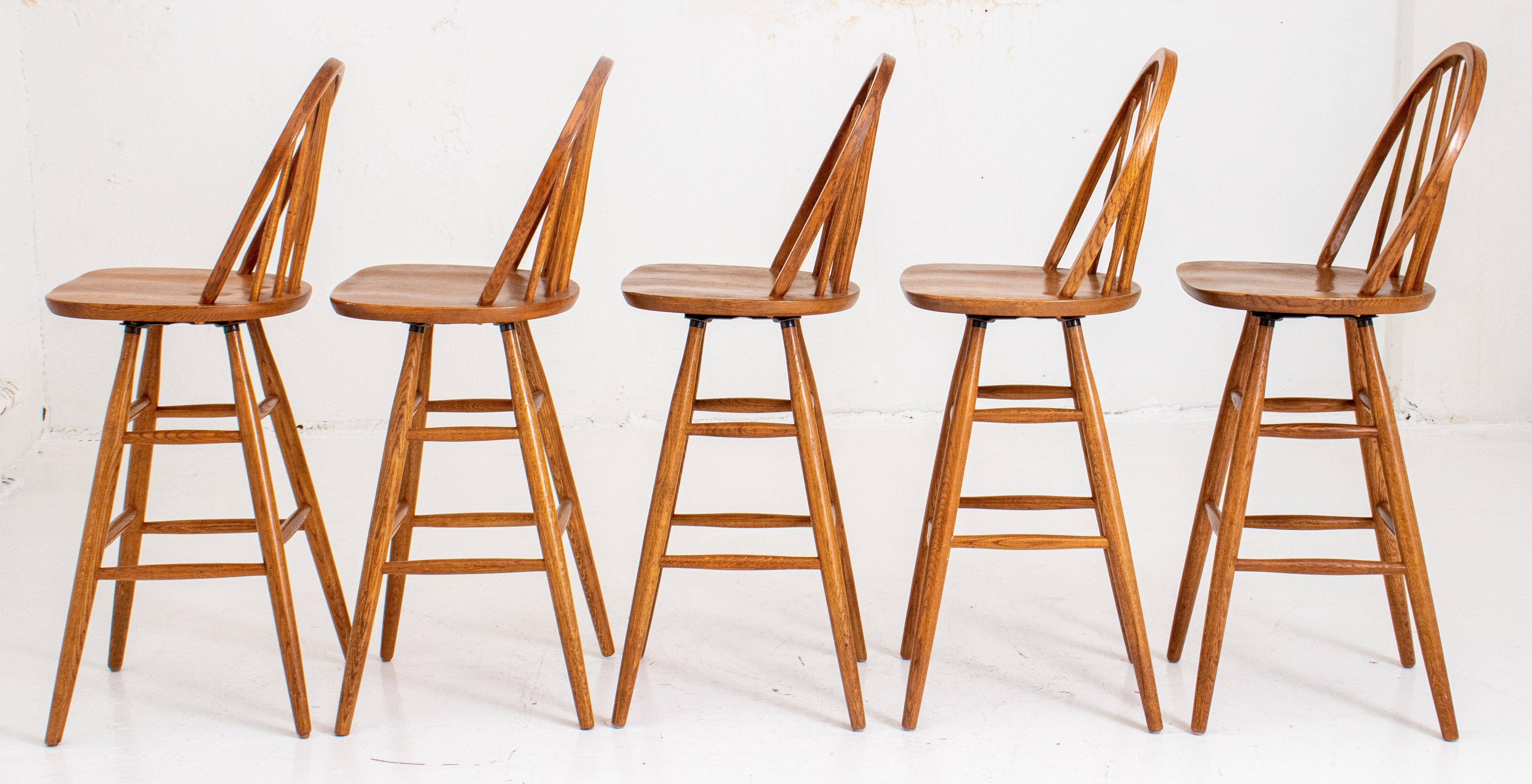(Five) with arched back in typical horseshoe form with turned support, molded shaped seat on swivel base above four tapering columnar legs with eight stretchers. Measures: 46