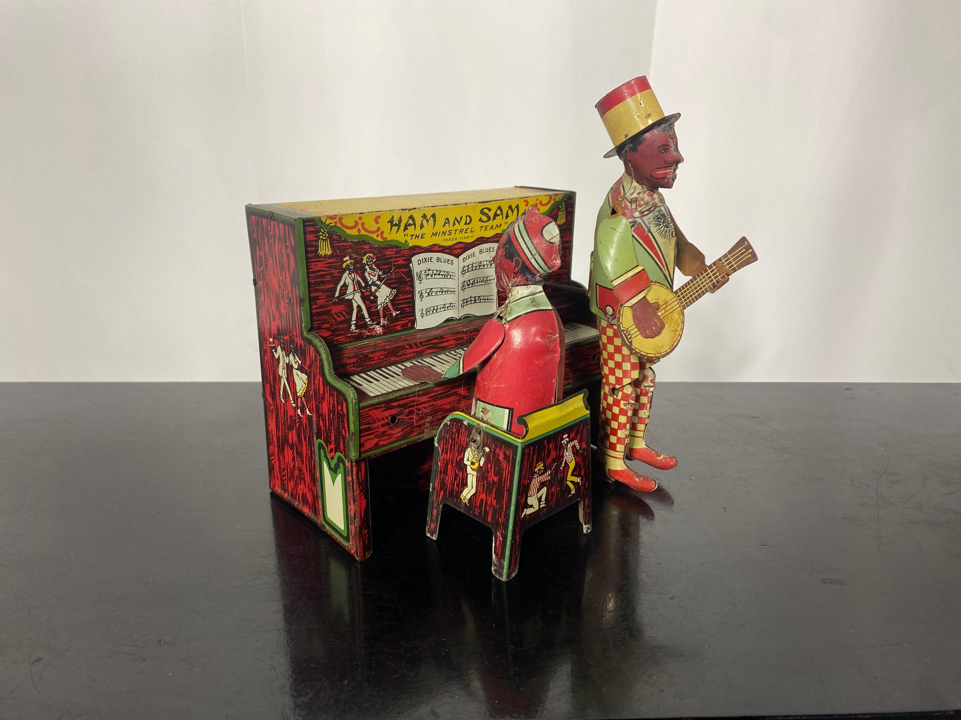 Americana Toy 
This is a tin, lithographed, windup Ham and Sam “The Minstrel Team” manufactured by the Ferdinand Strauss Company/Strauss Mfg. Co. of New York City, New York.  

When wound with its dedicated key and switched on, this working example
