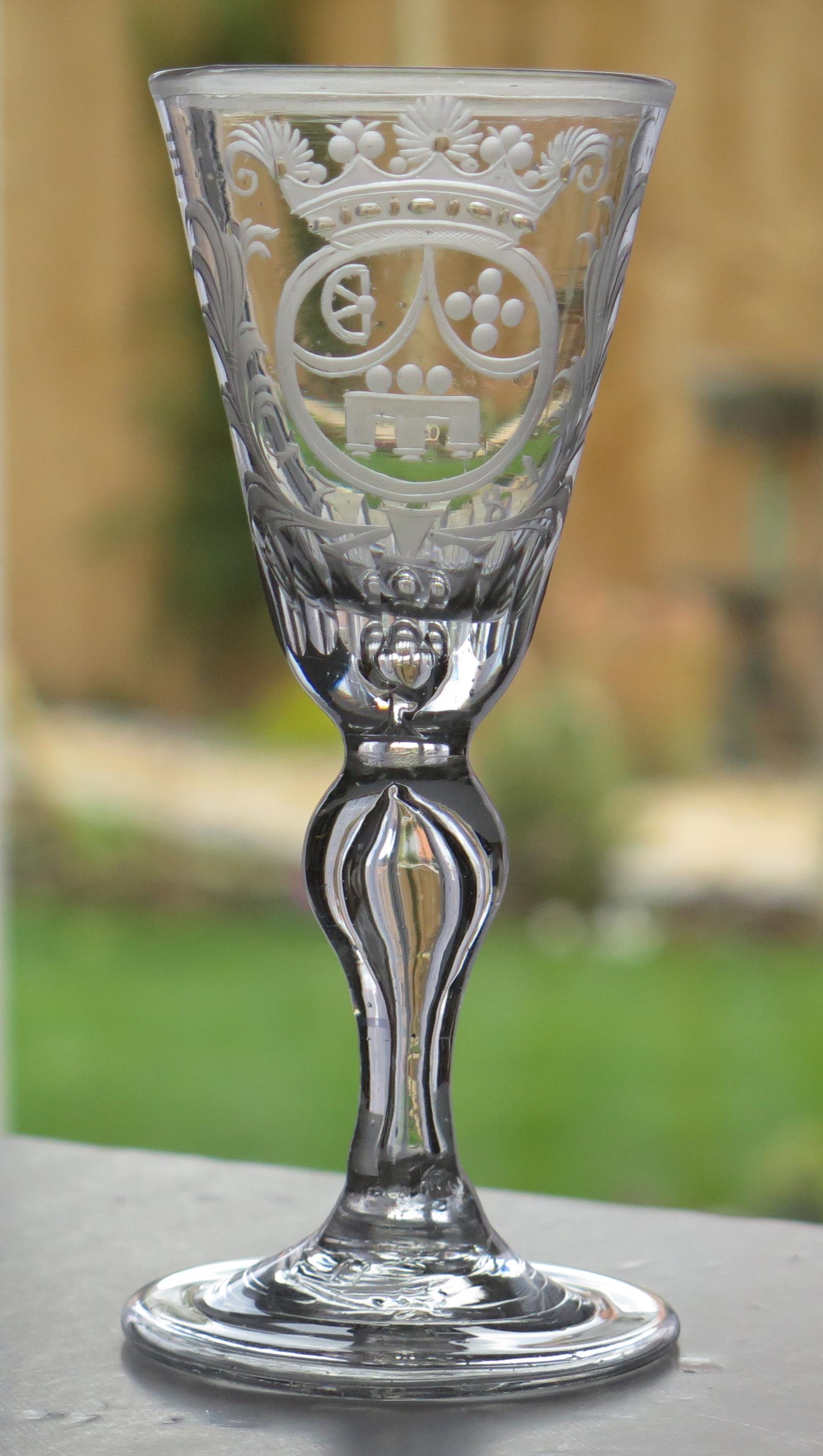 This is a very good, mid European, mid-18th century, handblown, wine drinking armorial glass; the bowl having an engraved crown coronet, circa 1740.

These glasses are very collectable.

This wine glass is hand-blown with a soft grey color. 

The