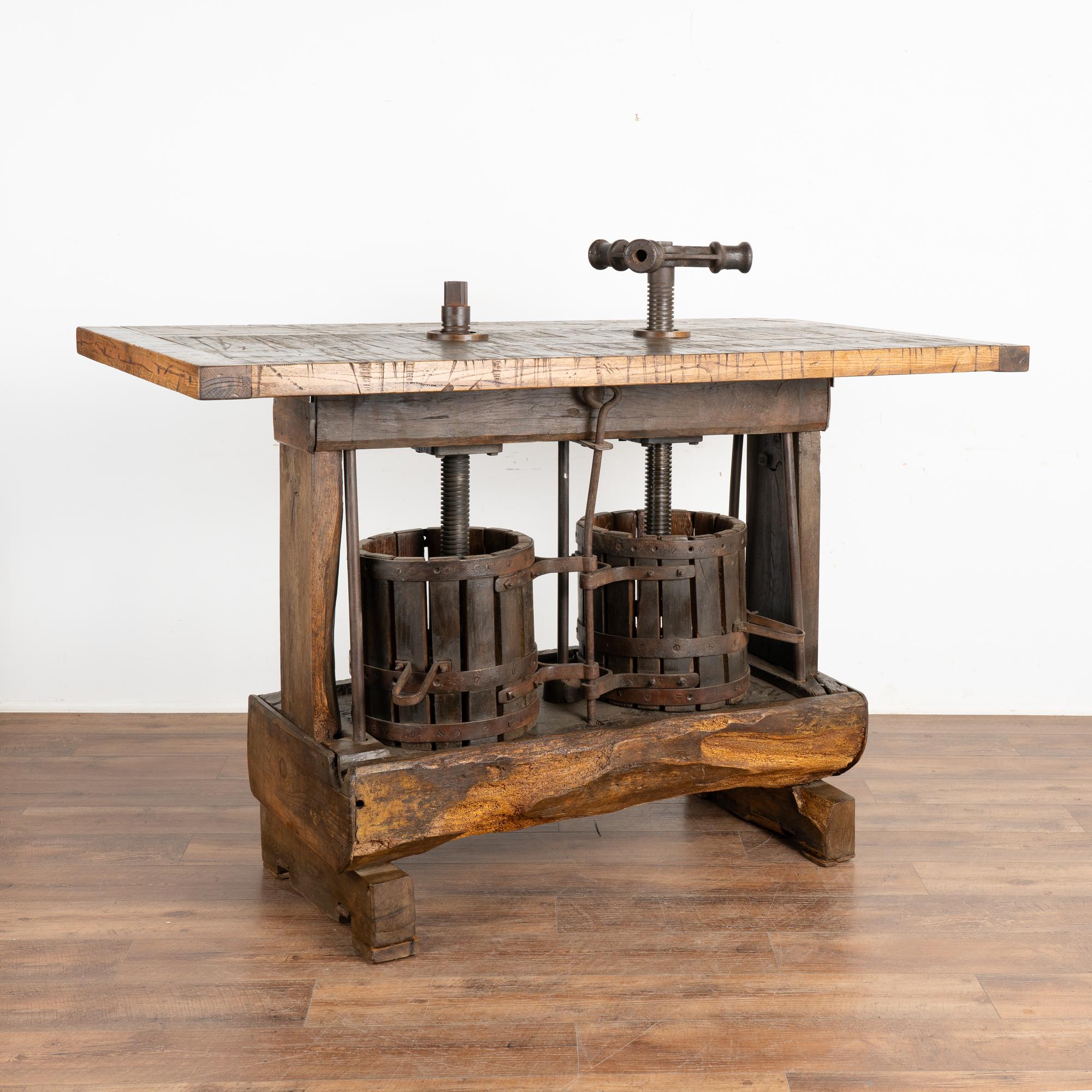 This exceptional wine tasting table or standing bar table was creating using an antique double wine press from Hungary serving as the unique and impressive base.
The top is made from old boxcar/railroad cart flooring with extensive distressing which