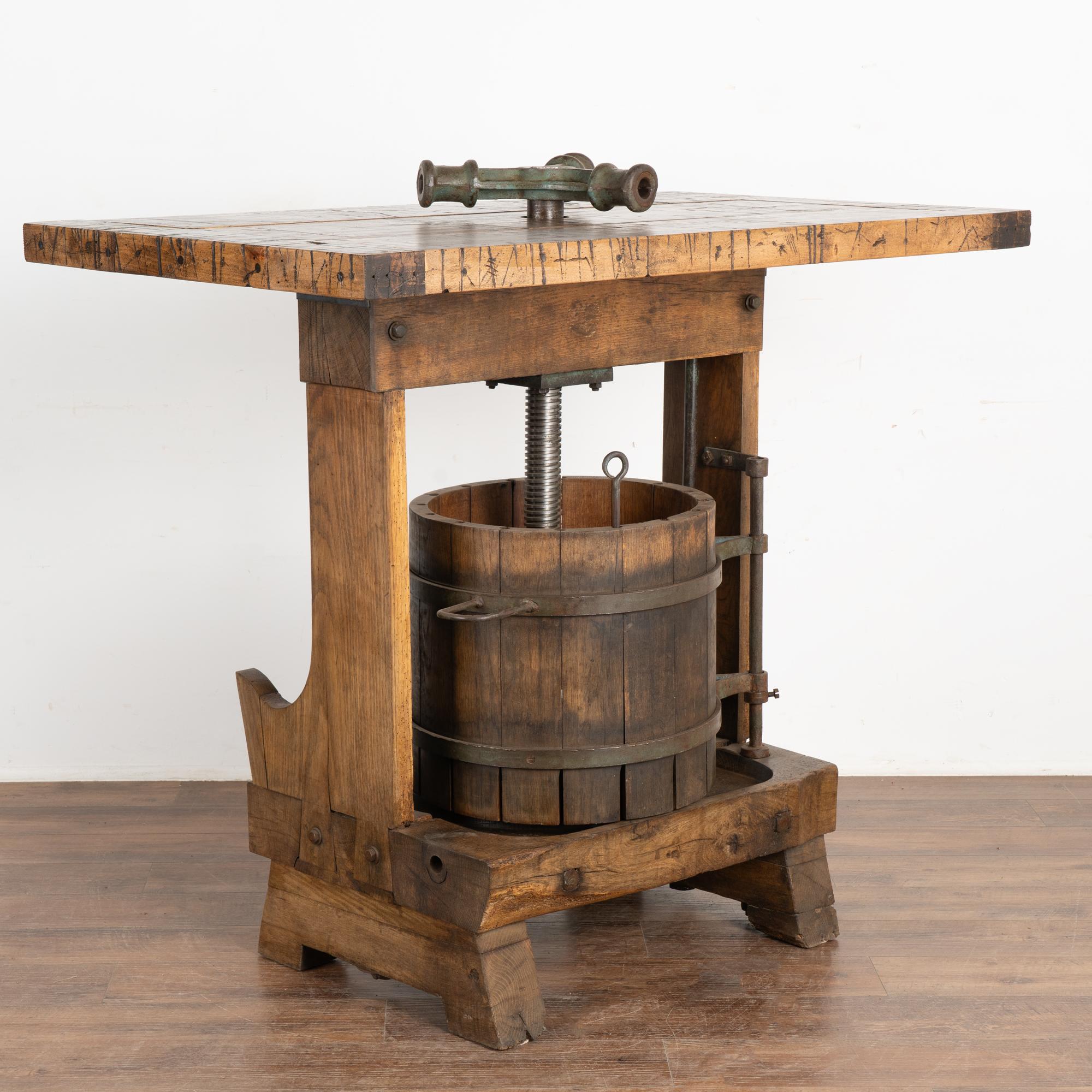 This unique wine tasting table or standing bar was created with an antique wine press from Hungary as the intriguing base.
The top is made from old boxcar/railroad car flooring which lends a strong balance to the industrial feel of the lower wine