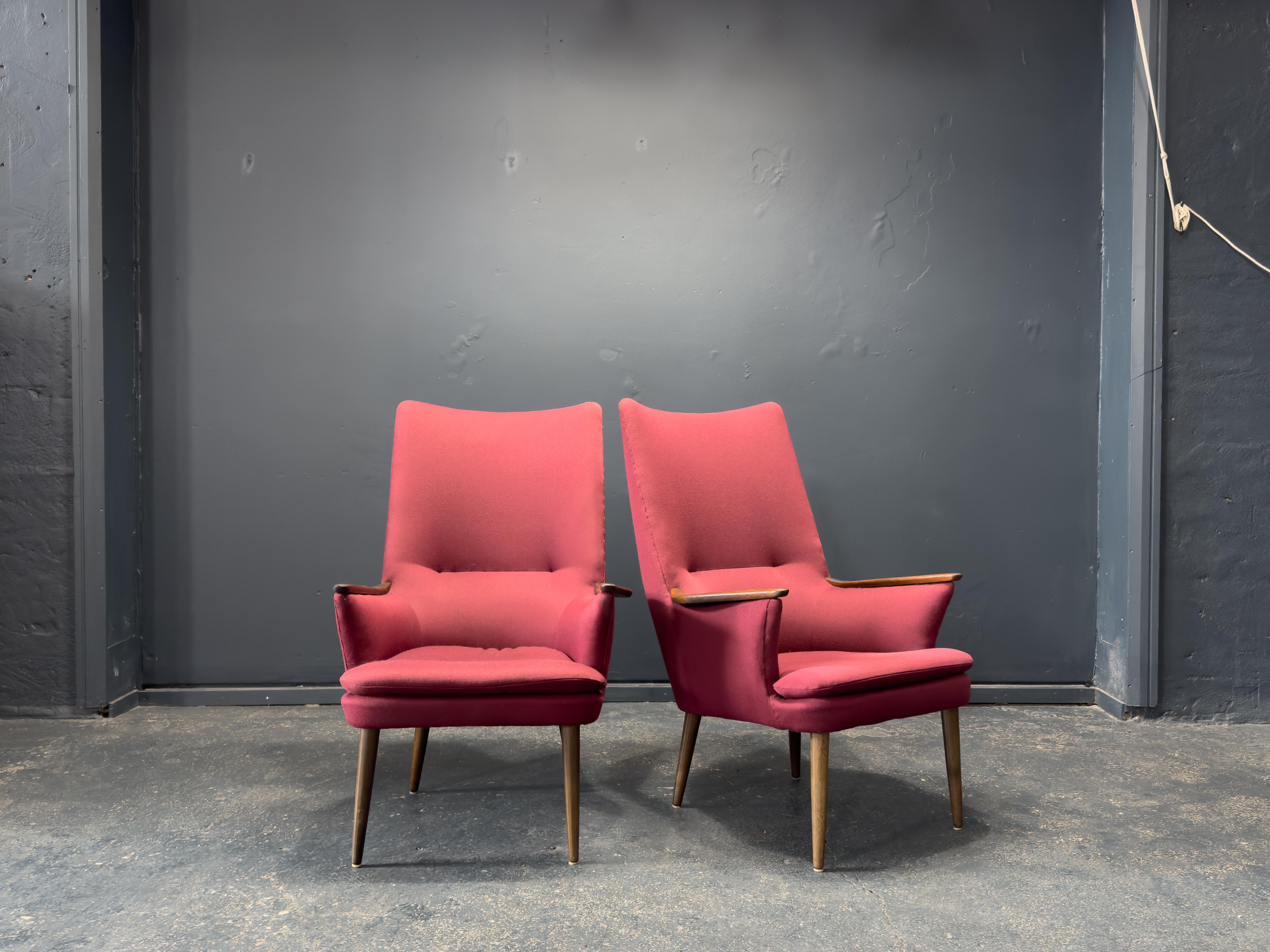 Dieser weinfarbene Sessel ist ein markantes Beispiel für das Design der Jahrhundertmitte, das sich durch seine kühne und zugleich elegante Silhouette auszeichnet. Die hohe, leicht geflügelte Rückenlehne verjüngt sich sanft zum Sitz hin und schafft