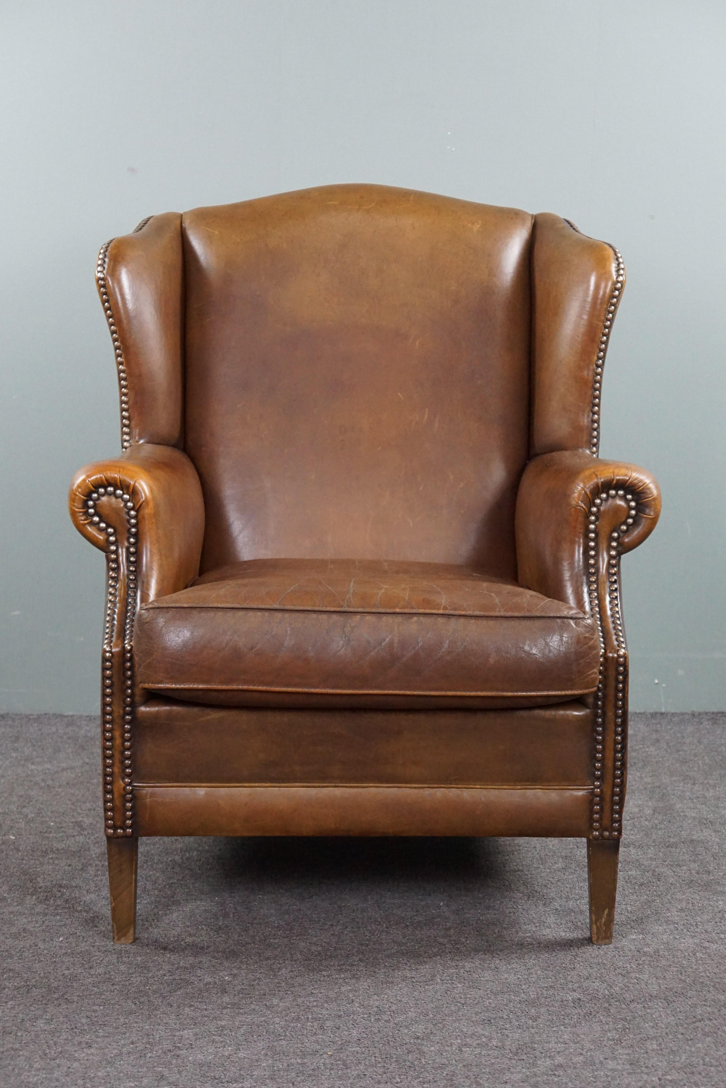 Offered is this beautifully colored speaking sheepskin leather wing chair.

This sturdy wing chair has a common appearance due to its color and design and can therefore be used in many interior types and places. The armchair is comfortable and is