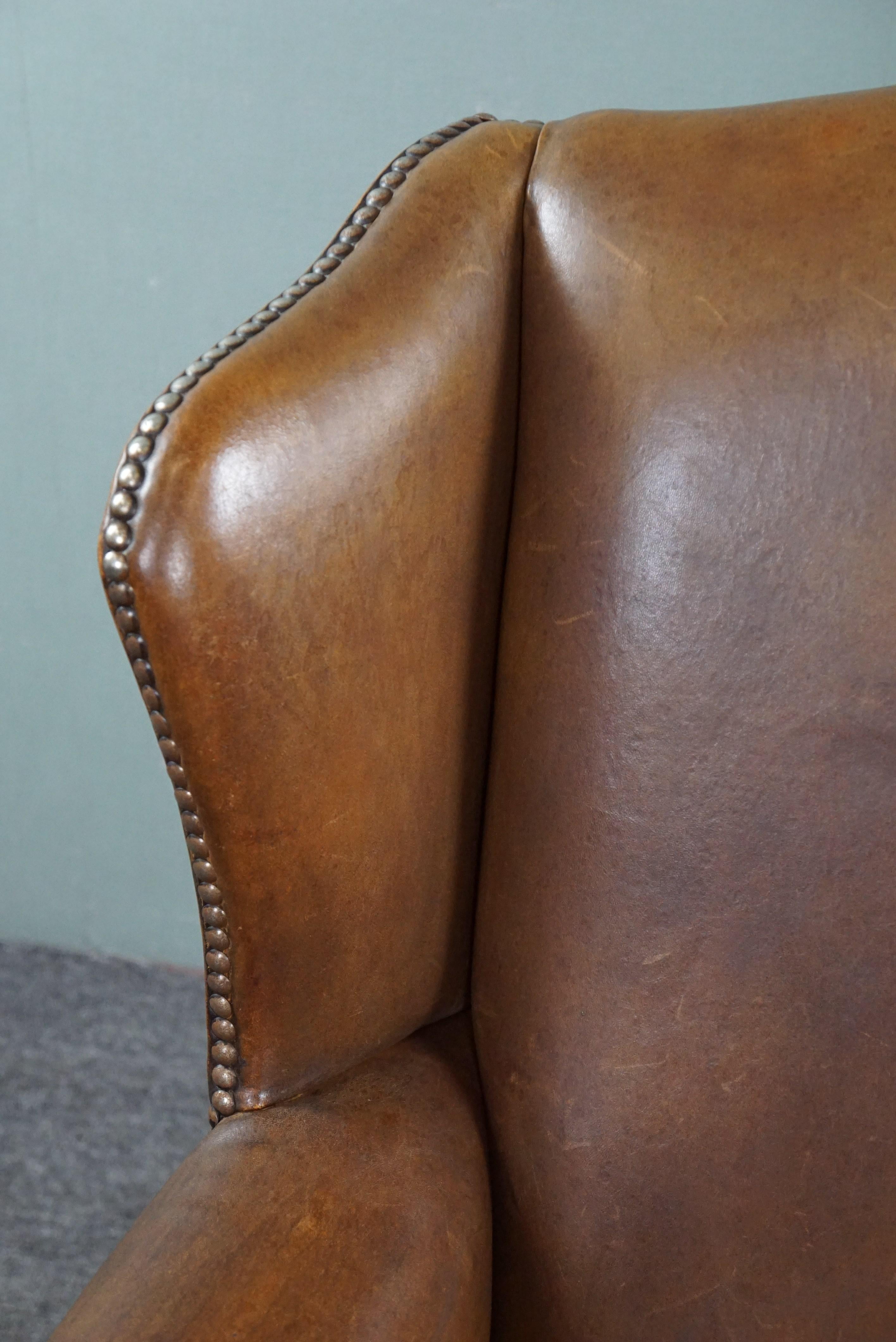 Leather Wing armchair full of character, made of sheep leather For Sale