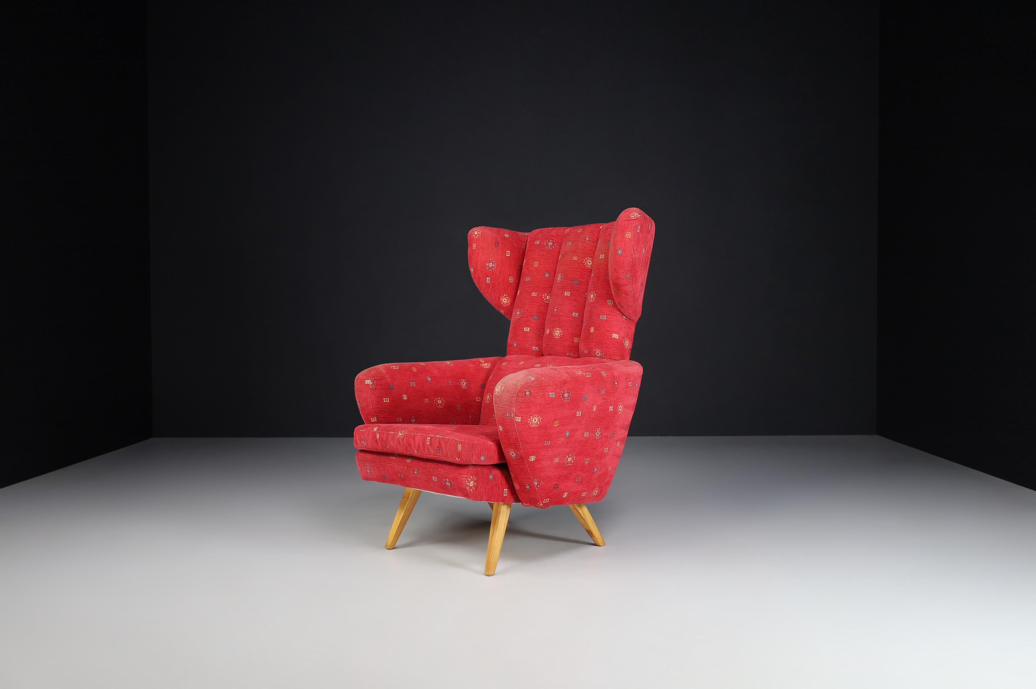 Wing Back Lounge chair in red Upholstery, Praque 1950s

Large midcentury wingback armchair in red upholstery, Czech republic 1950s. This armchair would be an eye-catching addition to any interior, such as a living room, family room, screening
