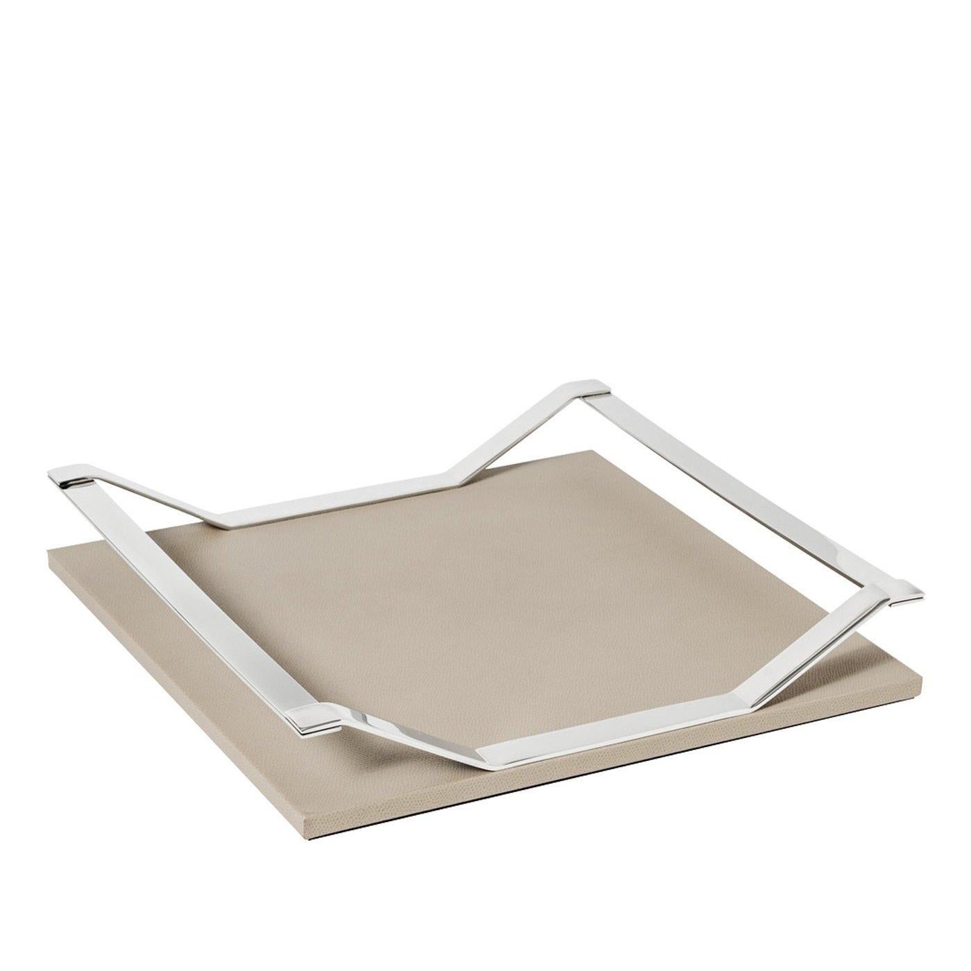 Part of the Wing collection of trays, this elegant piece has a square structure in wood that was upholstered in leather with a beige color and a non-slip material on its bottom. The metal handles have a chrome finish and are shaped as a pair of