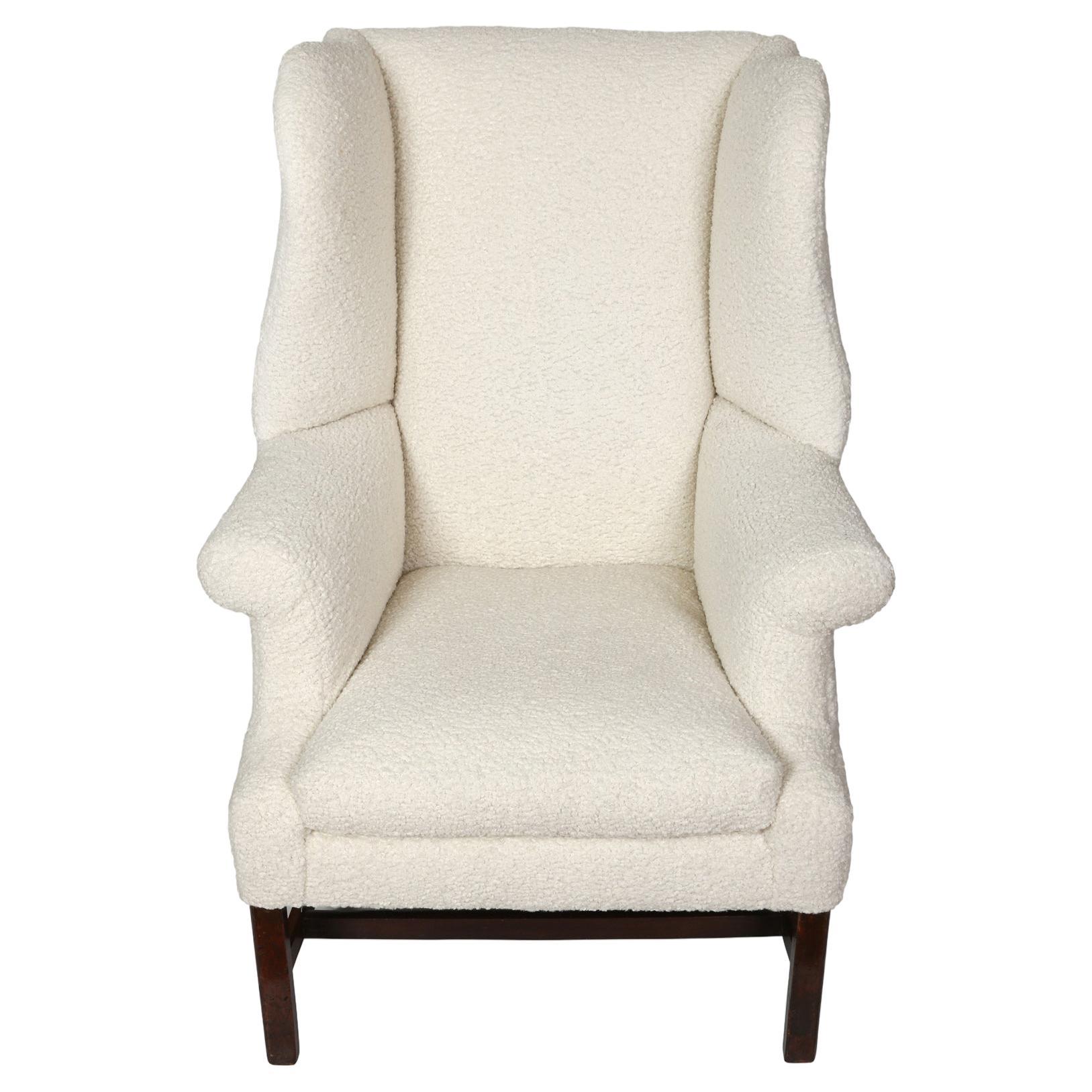 This handsome wing chair invites you to curl up w with a good book by the fire!  Upholstered in a cozy cream colored bouclé, the generously scaled chair features wide curved 