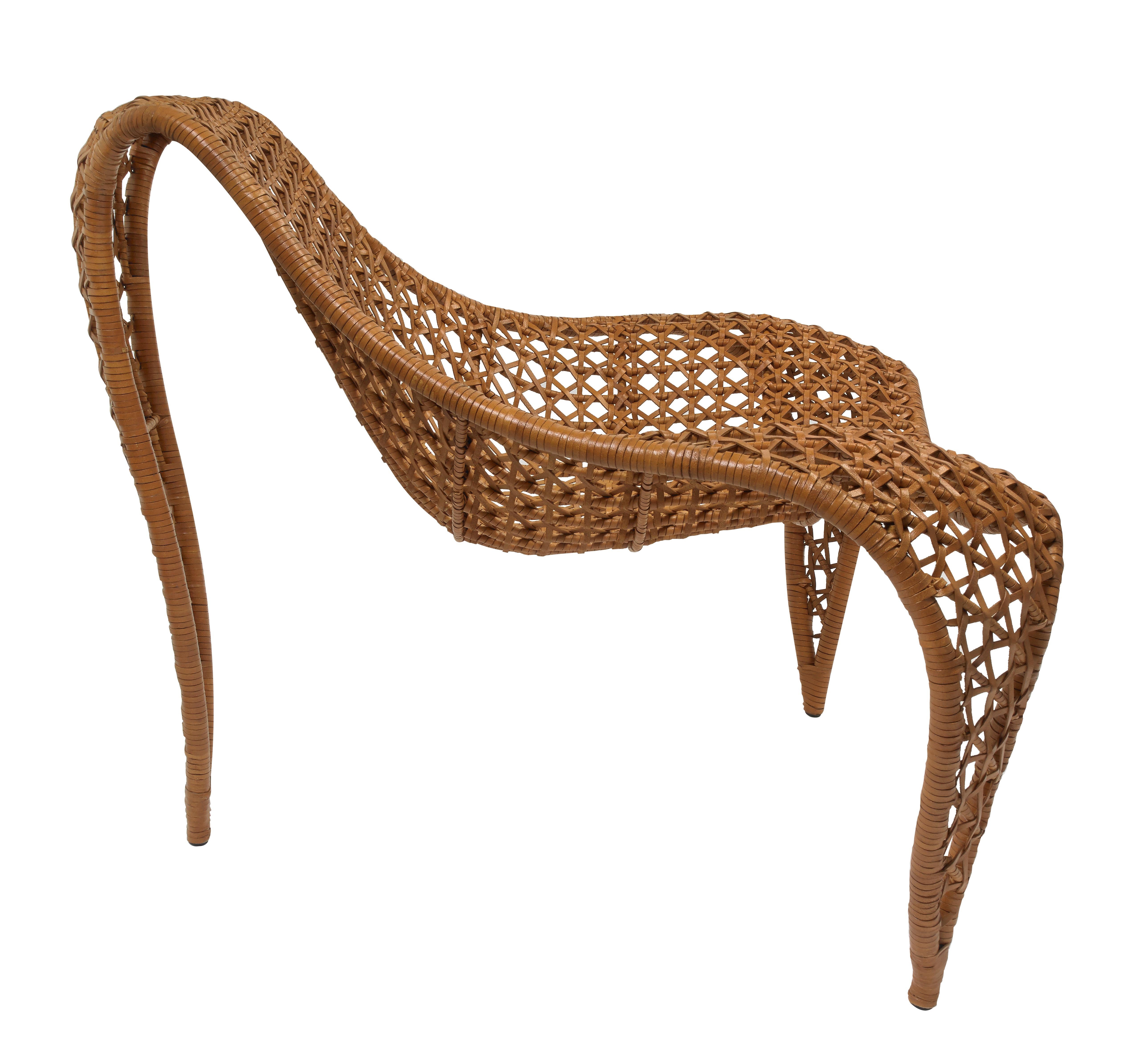 To enhance both style and comfort, supple woven leather gracefully envelops an intriguingly shaped chair.