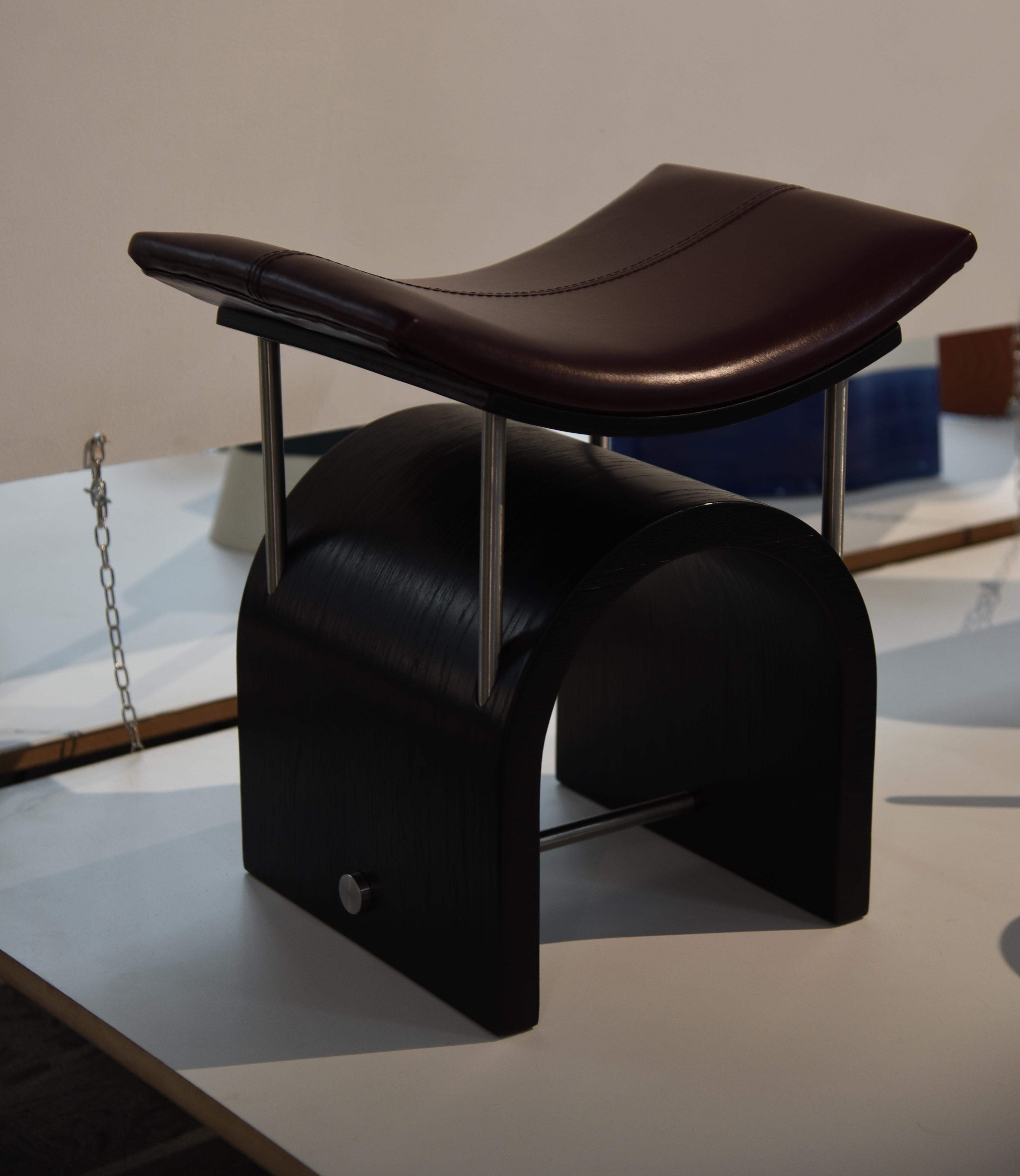 Wing stool by Studio Laf 
Dimensions: L43 cm x W35 x H44 cm
Materials: Plywood, Stainless Steel, Leather
Available: different colors Leather: Brown, Black, Antique Brown, Cherry Red. Also available in Wood: Black, Walnut, Dark Walnut.

It