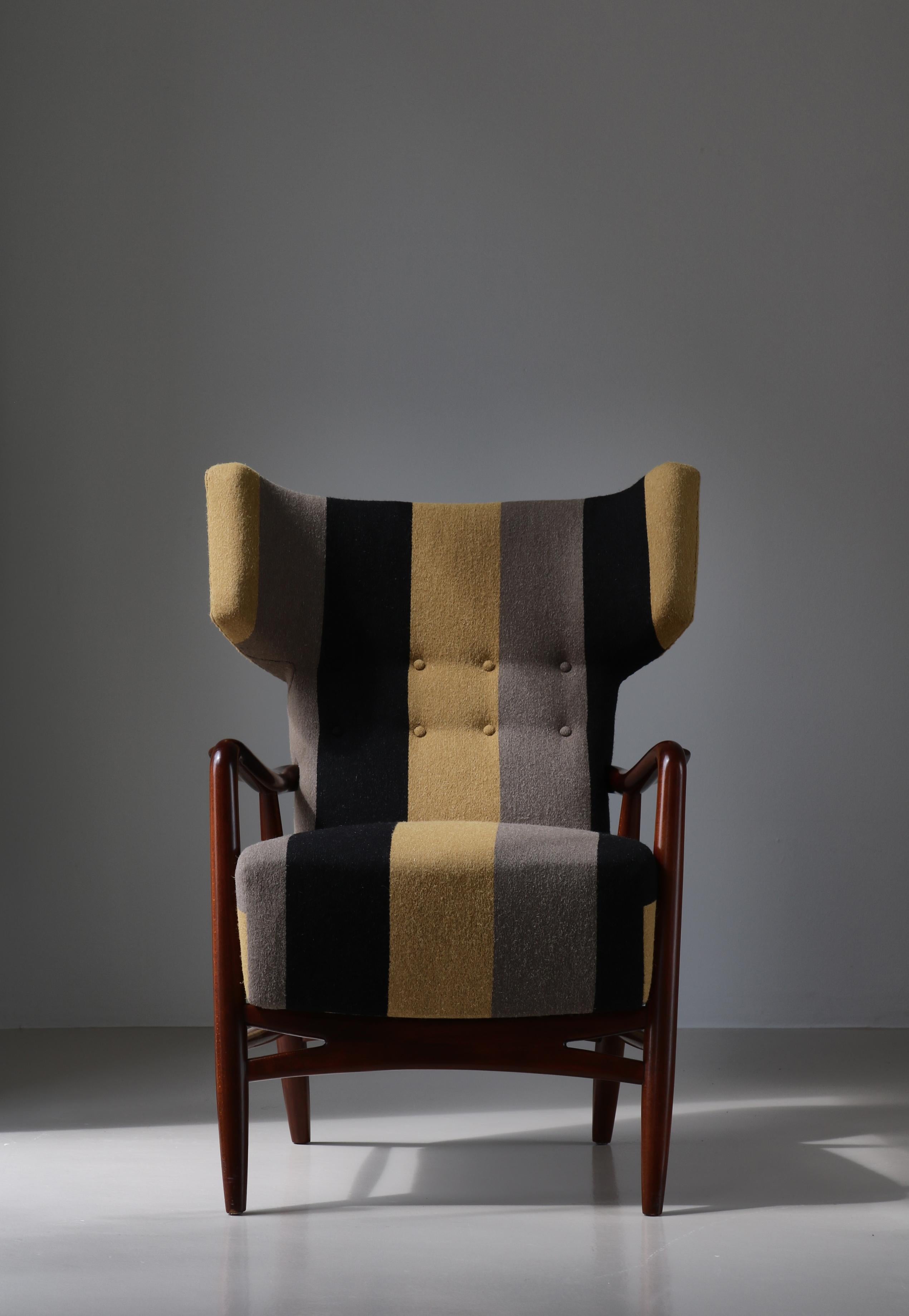 Important et rare fauteuil à oreilles conçu par Eva &Nils Koppel en 1947 et fabriqué à Slagelse Møbelværk, Danemark. Fabriqué en hêtre teinté foncé et rembourré dans un tissu Kjellerup Weaver fait sur mesure, Danemark.

Eva Koppel était, avec Nanna