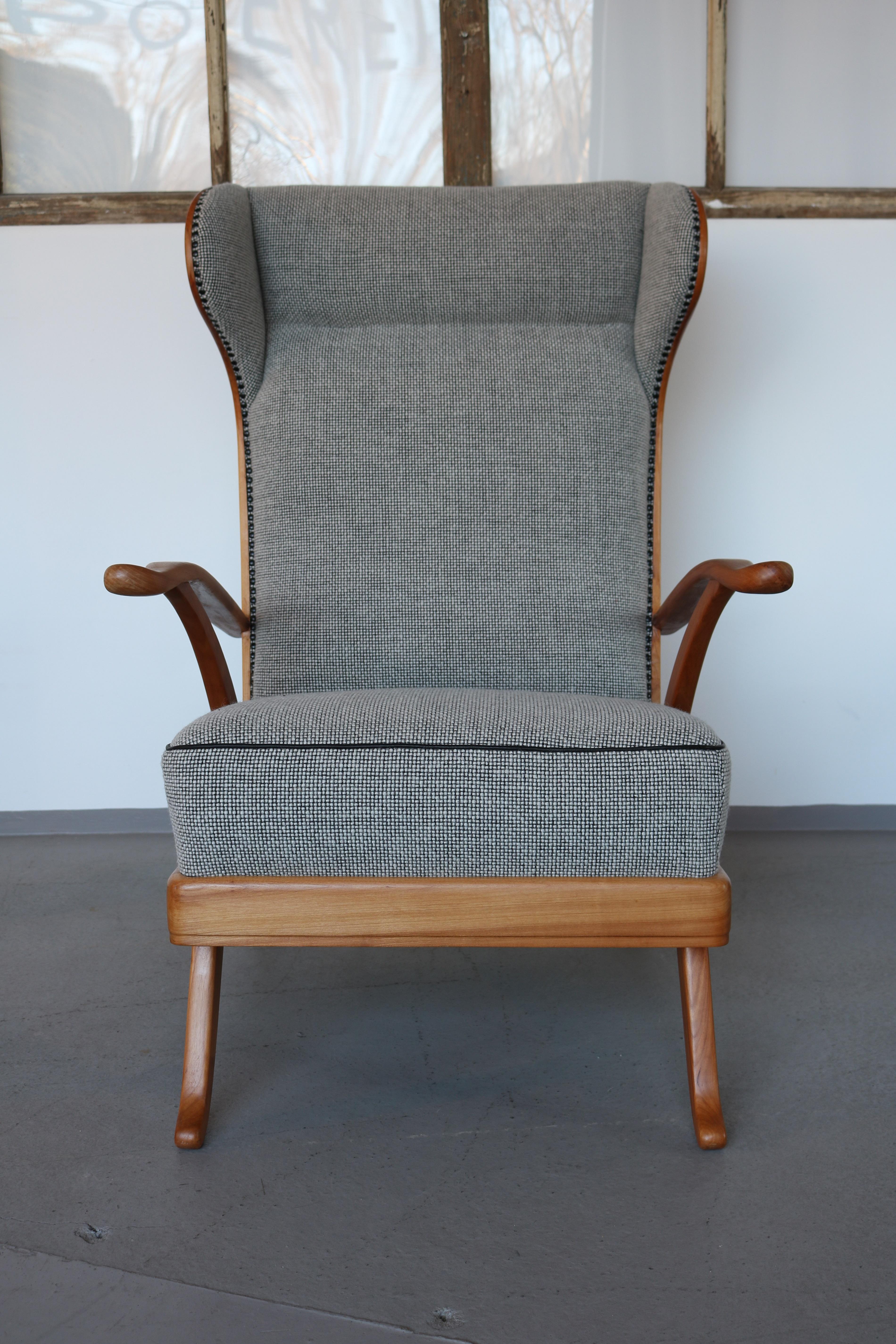 Wingback chair design Karl Nothhelfer for Schörle & Gölz, Stuttgart-Bad Cannstatt 1950s.
The frame is made of solid cheerywood. The upholstery has been completely redesigned and upholstered with a high-quality new-wool fabric in salt-pepper from