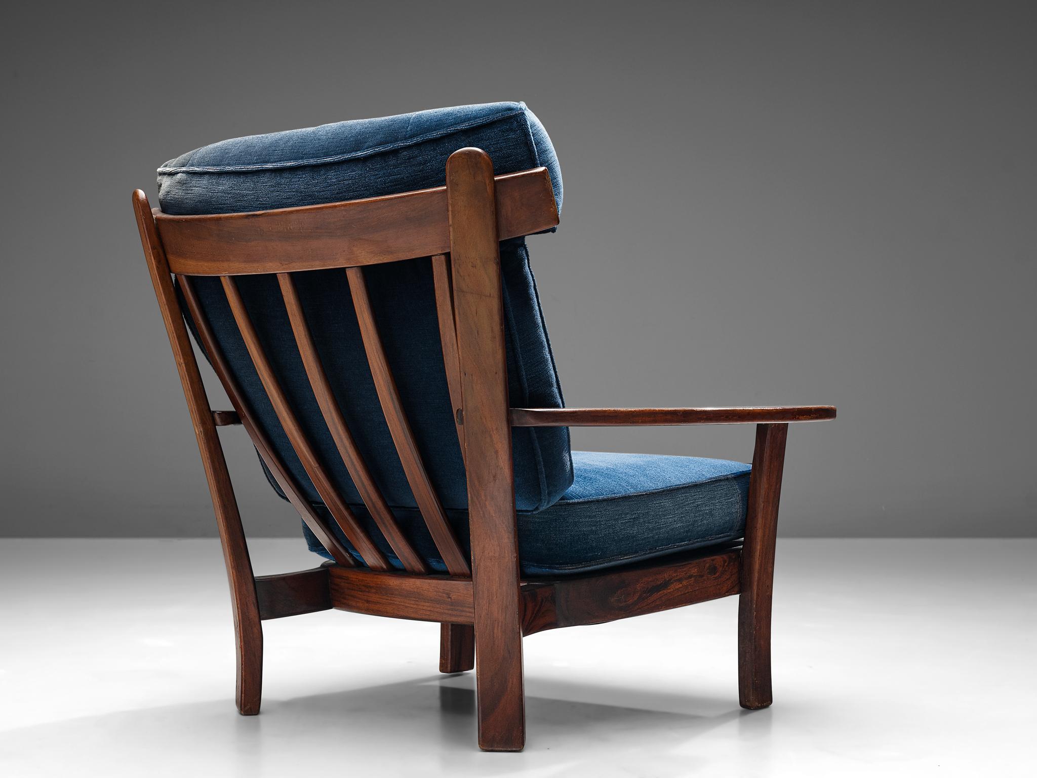Lounge chair, solid hardwood and velvet blue upholstery, Europe, 1960s.

This stately and well-executed lounge chair shows beautiful craftsmanship. The chair is constructed in a refined manner, showing clear lines and harmonious combination of