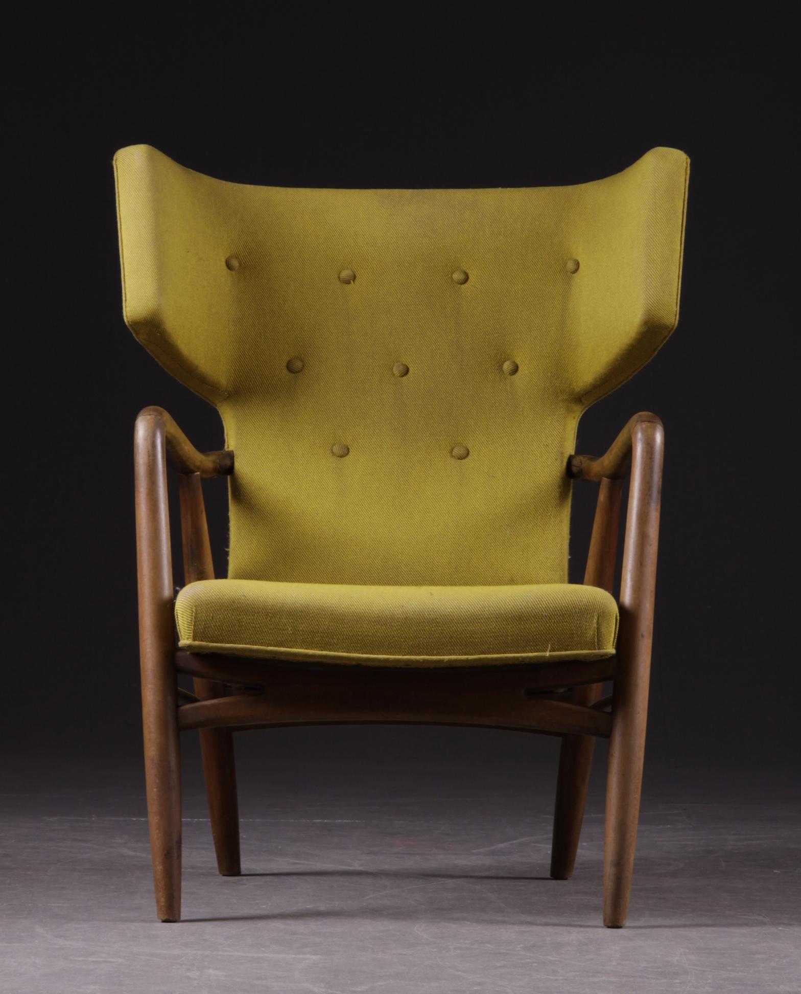 Important and rare  wingback armchair designed by Eva Koppel in 1947 and manufactured at Slagelse Møbelværk, Denmark. 
Made from dark stained beech original yellow fabric 
Good condition 

Eva Koppel was, along with Nanna Ditzel, one of the most