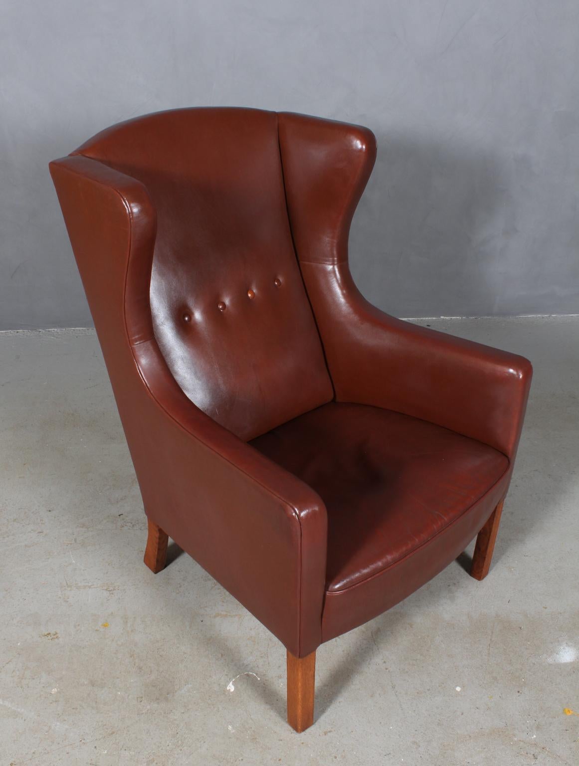Børge Mogensen wingback chair in original brown leather upholstery with buttons.

Legs of solid oak.

Model L3, made by FDB Møbler, 1950s.