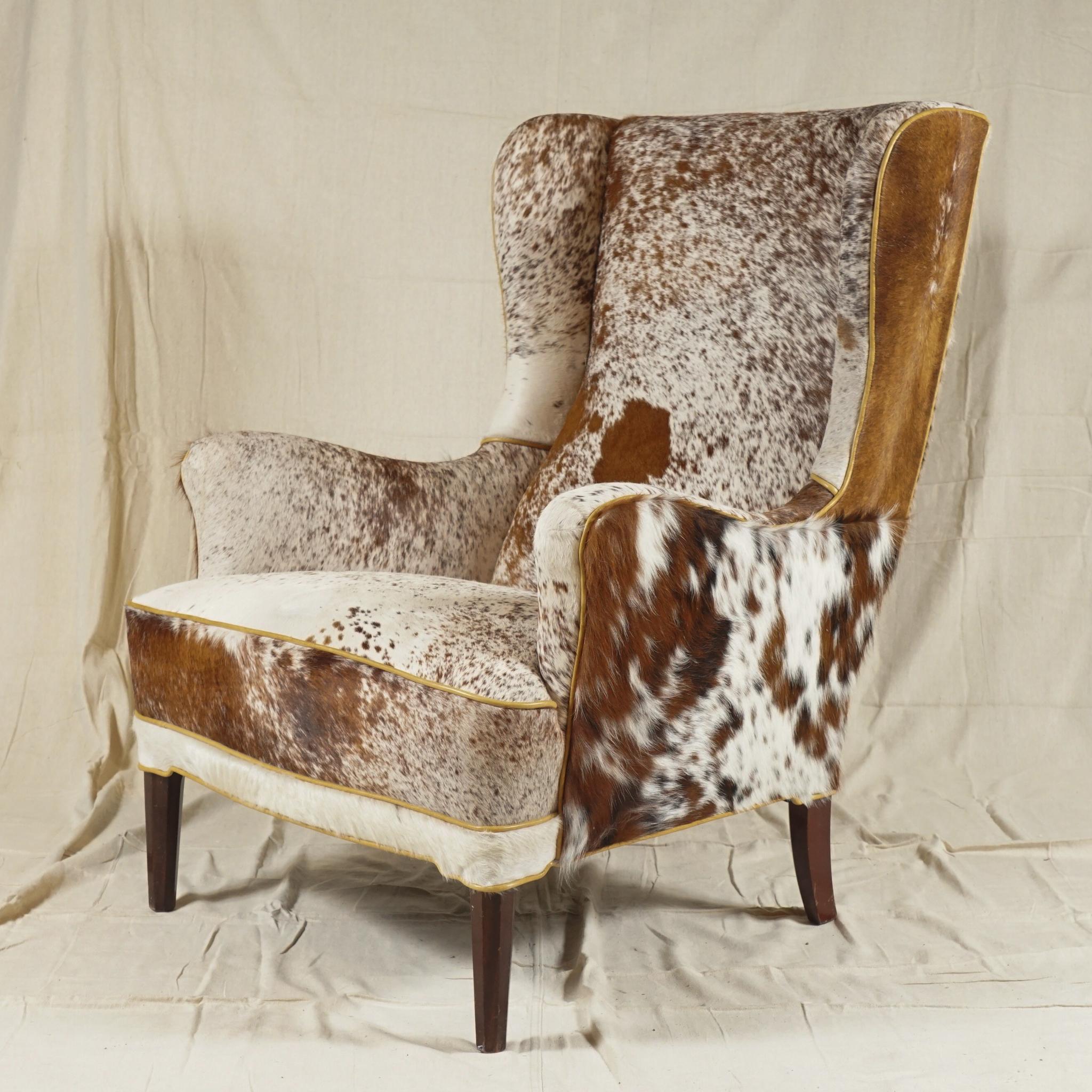 A Wingback Armchair by Danish designer Frits Henningsen, recovered in soft cowhide, extremely 
comfortable. A pair available.

Frits Henningsen (1889–1965) was a Danish furniture designer and cabinet maker who achieved high standards of quality
