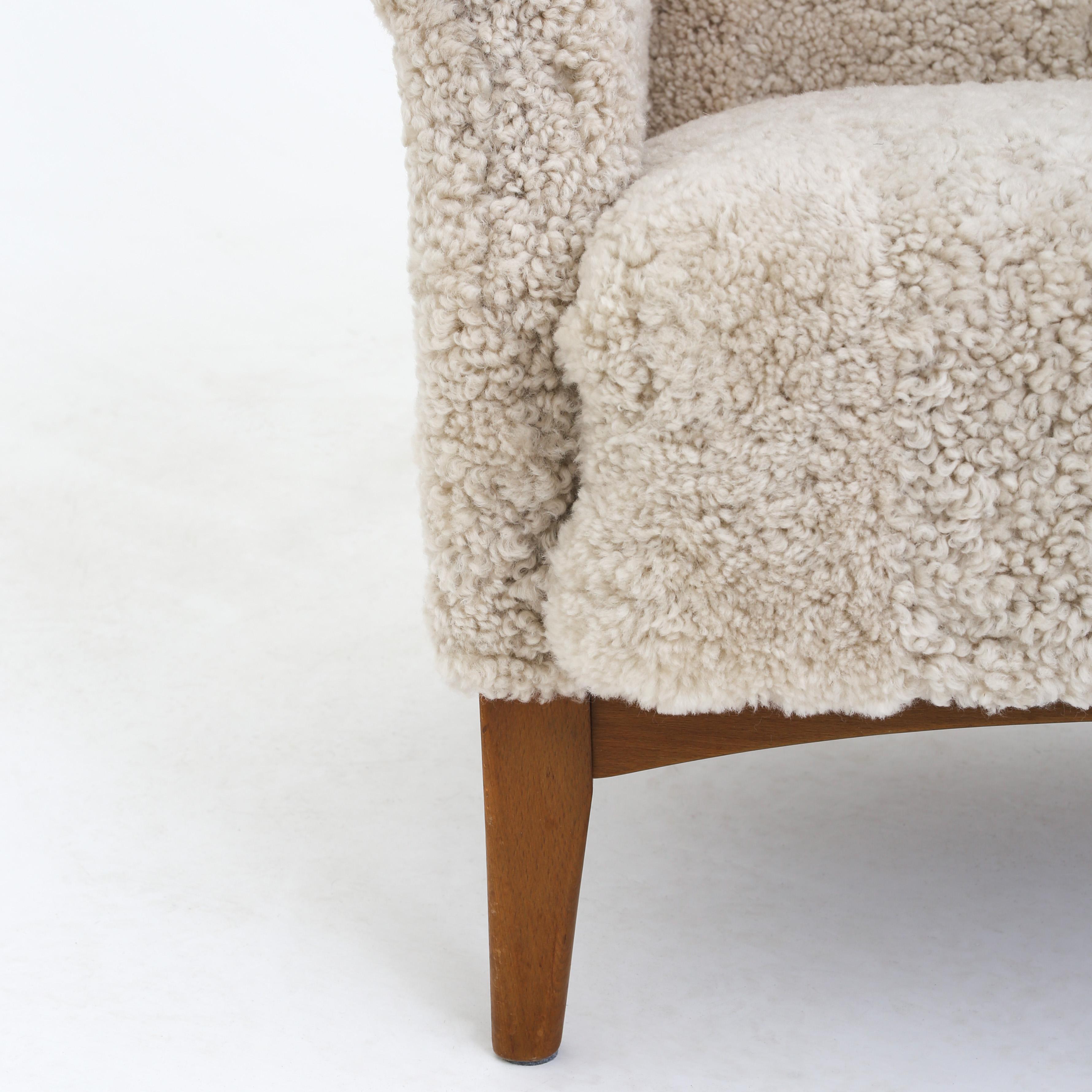 Fritz Hansen wingback chair (model FH 8023) in stained beech, reupholstered with Moonlight lamb's wool. Maker Fritz Hansen.