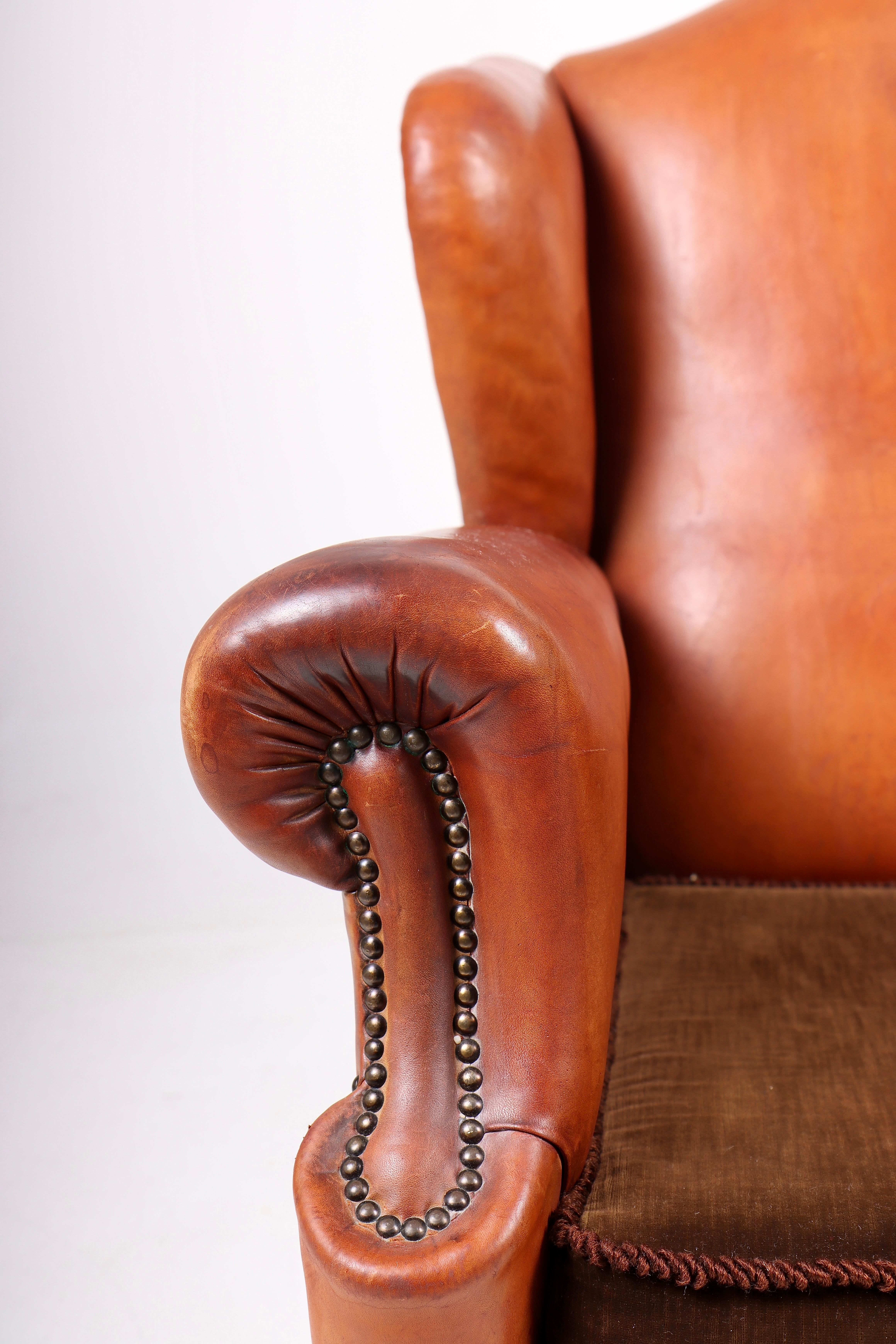 Great looking wingback chair in patinated leather. Designed and made in Denmark 1940s.