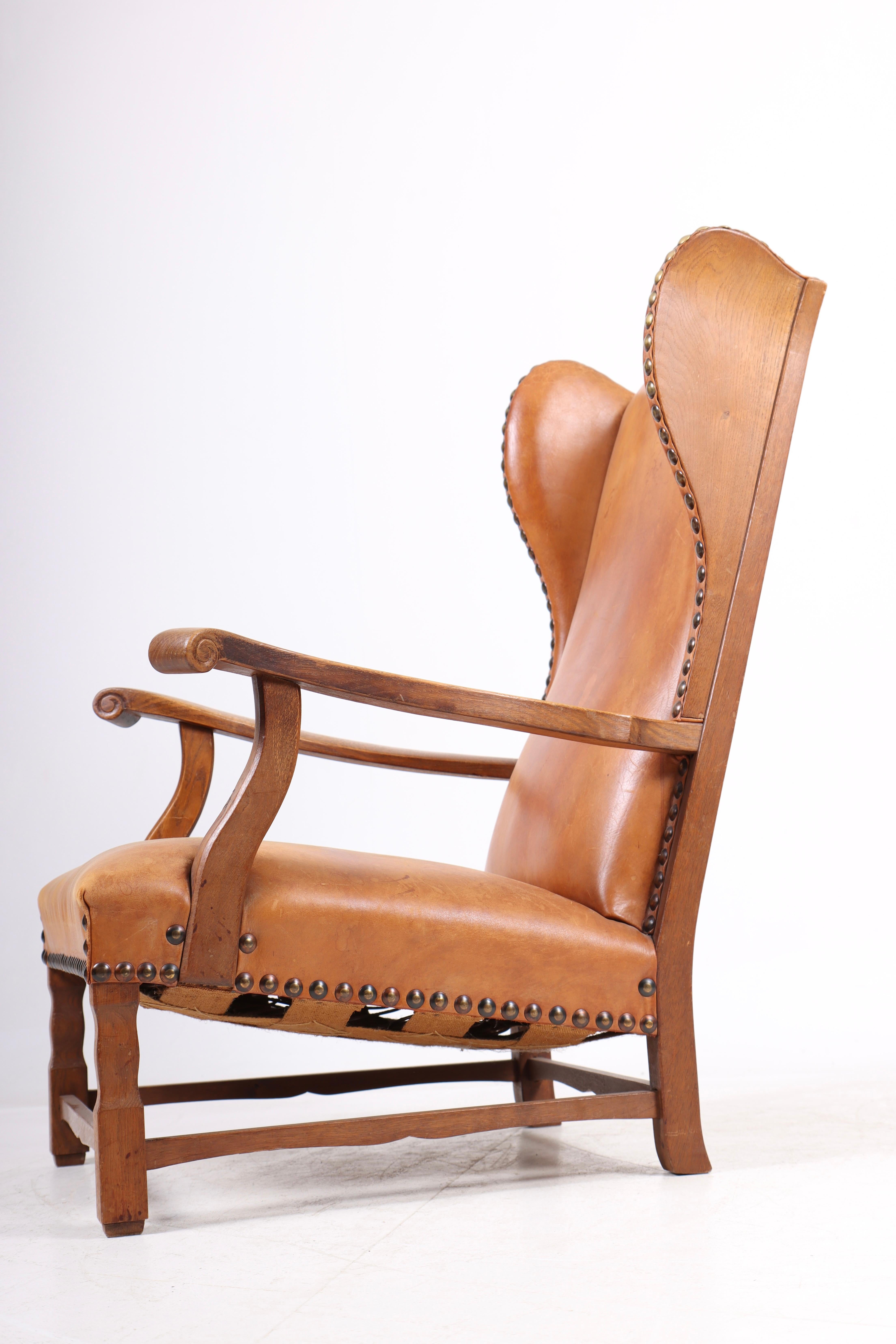 Silla Wingback de roble macizo y cuero patinado, ebanista danés, años 40 mediados del siglo XX