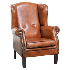 Wingback chair made of sheep leather with black piping in good condition