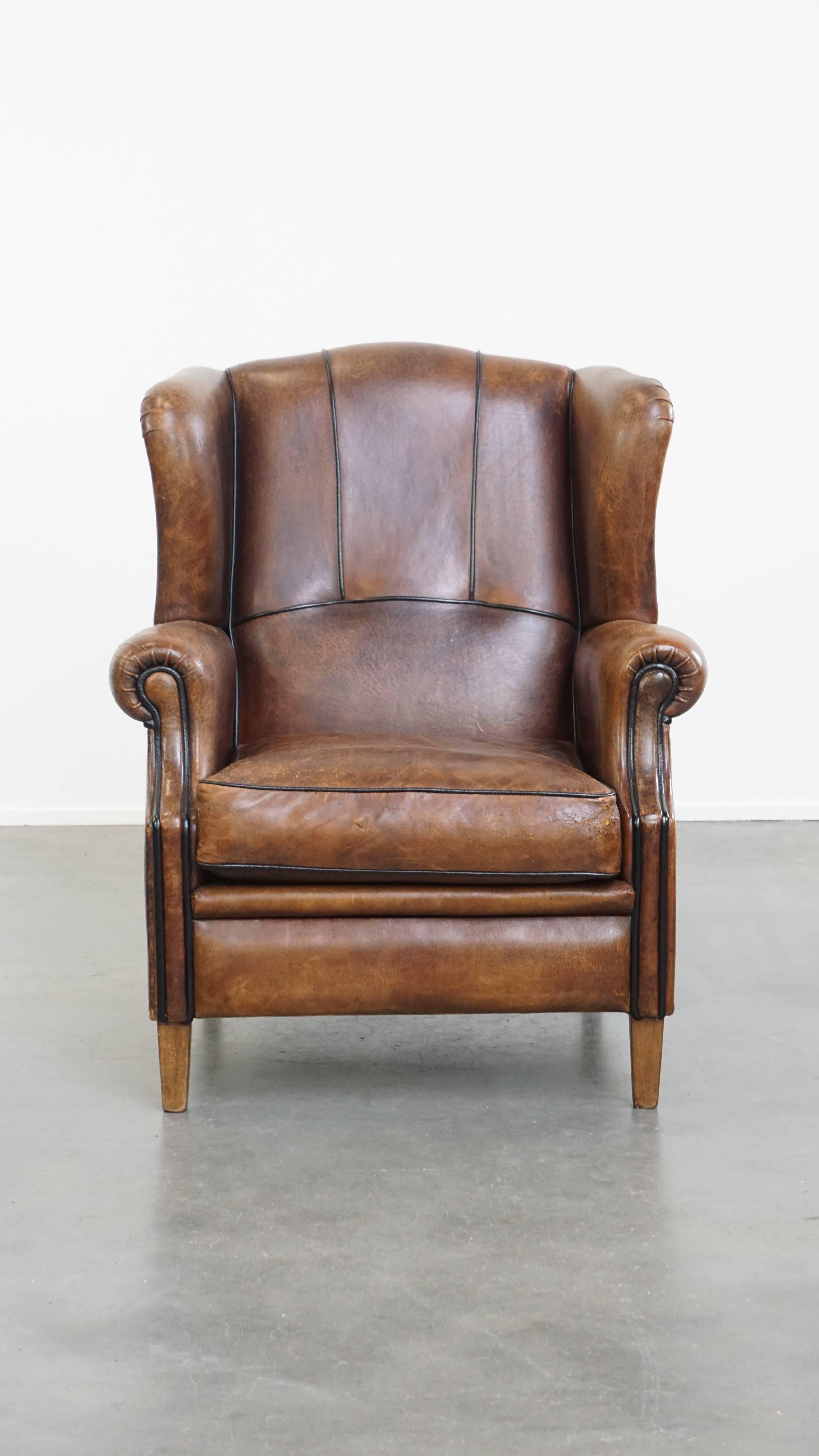 Nous vous proposons ce magnifique fauteuil à oreilles en cuir de mouton aux couleurs vibrantes et à la finition raffinée en passepoil noir. Ce fauteuil à oreilles en cuir de mouton est un objet intemporel qui, à notre avis, a sa place dans tous les
