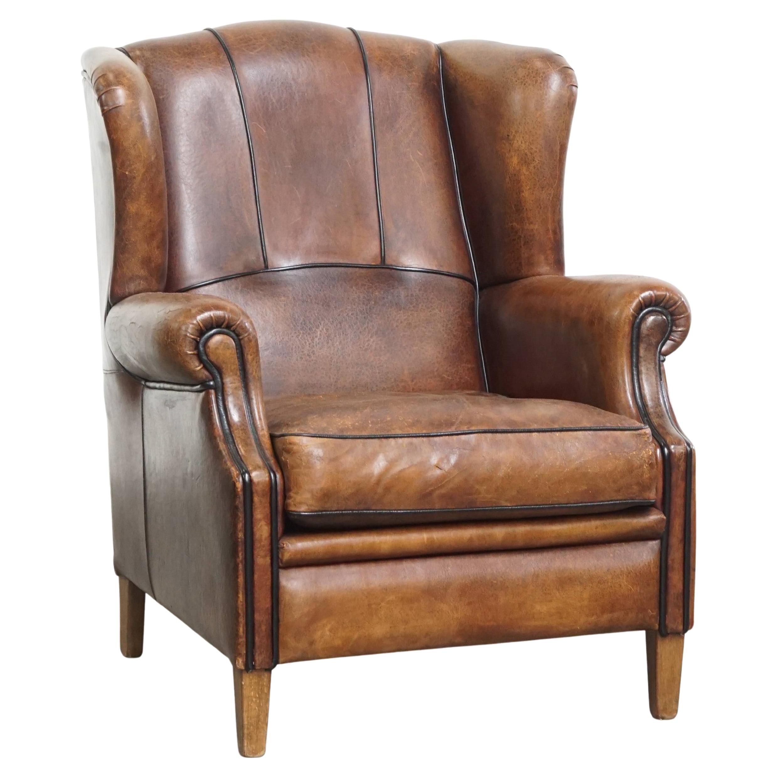 Fauteuil à dossier en cuir de mouton avec passepoil noir en vente