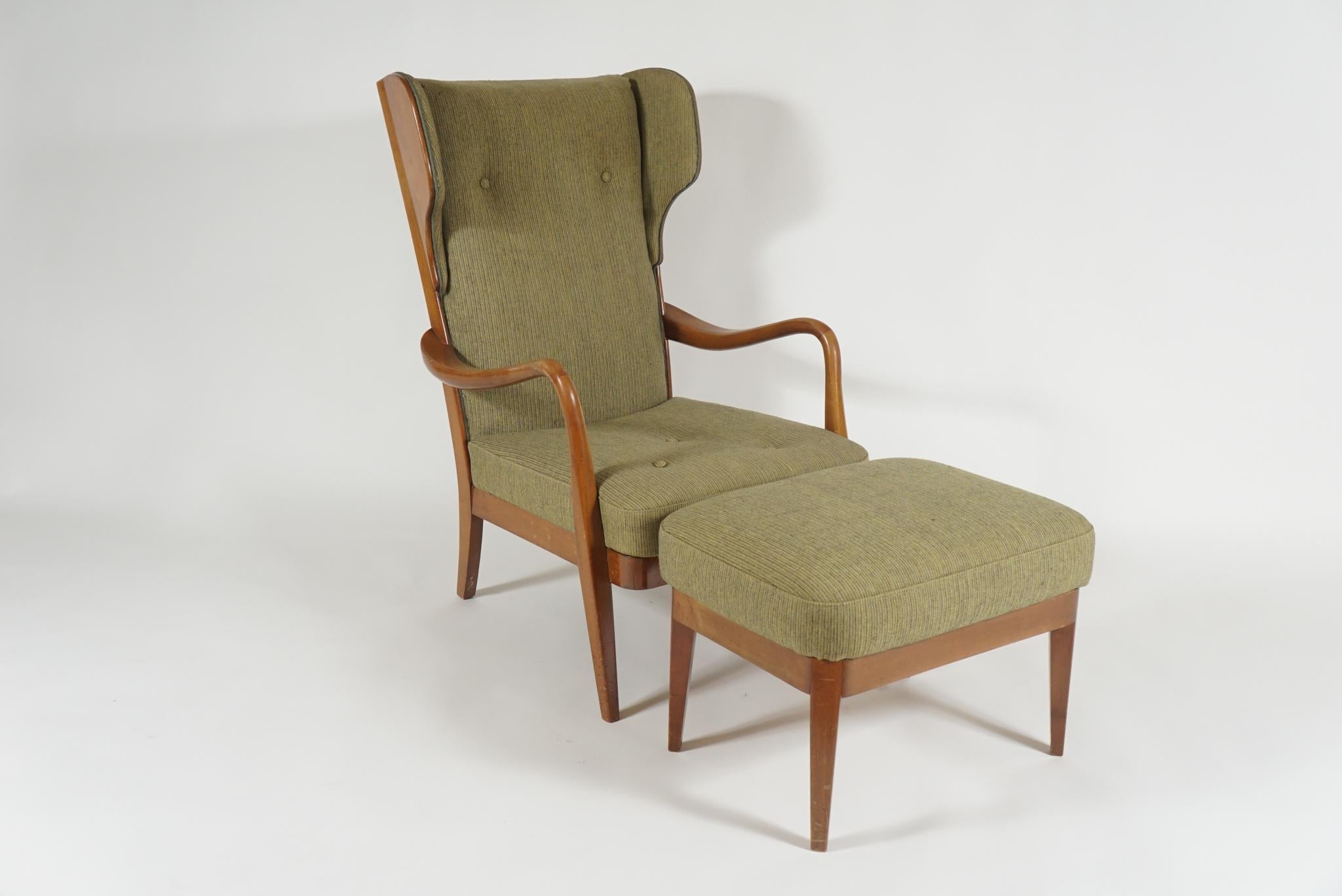 Handsome woodframe wingback armchair with matching ottoman, Danish modern in mahogany. Upholstered in original green wool, however will need the back re-upholstered as one side has cat scratches.