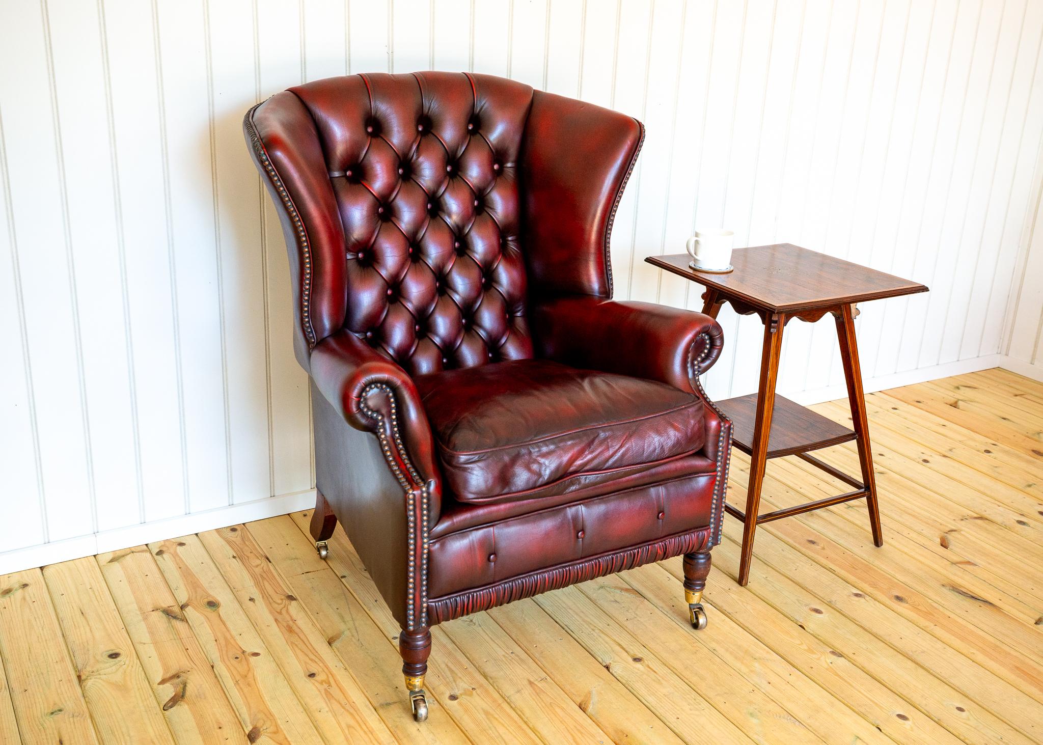 Rare et impressionnant fauteuil Chesterfield de style géorgien en cuir rouge sang de bœuf sur roulettes, d'excellente qualité et en très bon état. Vendu chez Harrods à Londres et produit en Angleterre au début des années 1990 par les fournisseurs de