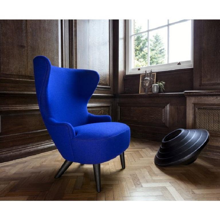 Micro Wingback is Tom Dixon's much appreciated armchair with its expressive sweeping curves that act as a sculptural intervention. This small armchair is upholstered using Bute's dark blue woolen fabric and features black oak legs. The wings provide