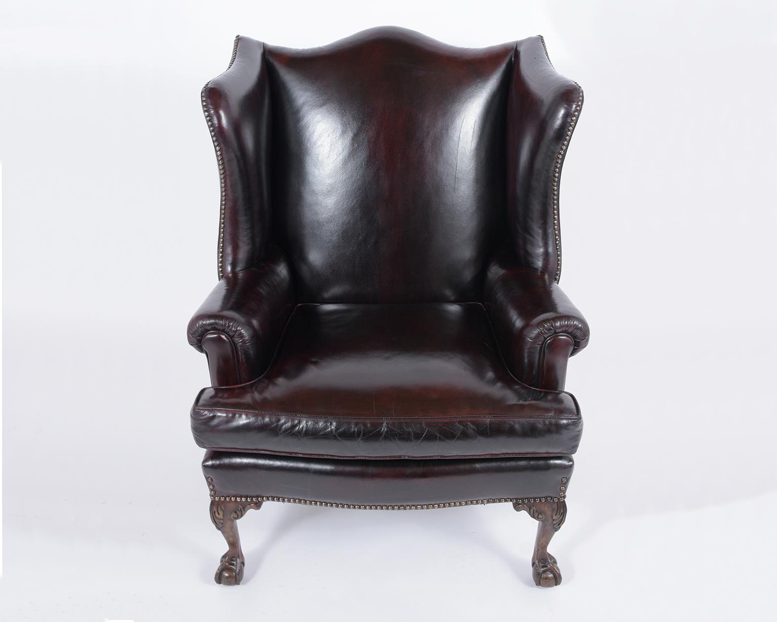 This 1970s wingback chair handcrafted out of solid wood, upholstered in comfortable leather, and is professionally restored. This elegant club chair features a wingback scroll arm a single cushion upholstery in a leather newly dyed in a dark