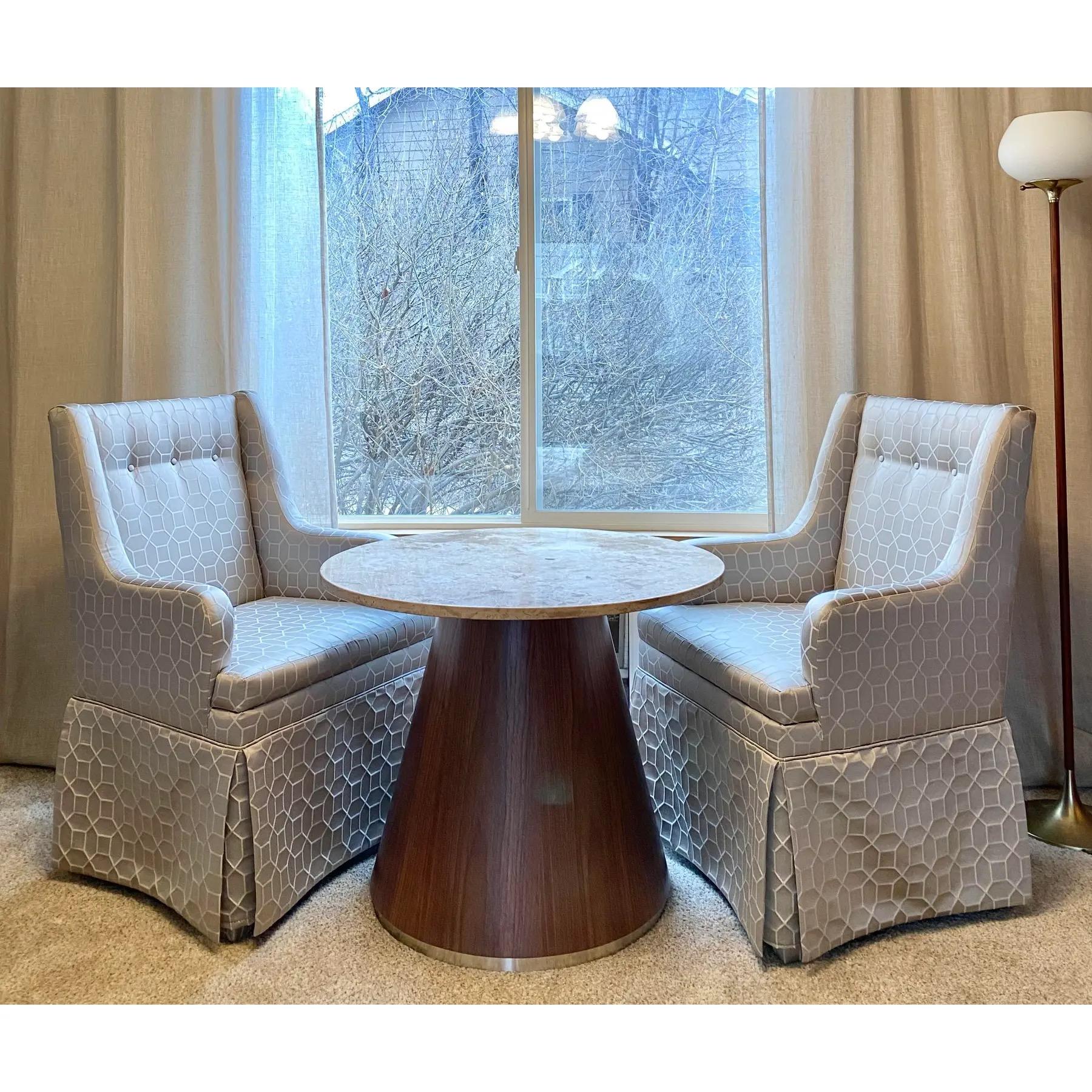 Un rivestimento geometrico in sateen color tortora e argento rifinisce questa coppia di sedie Parsons con zoccolo. Perfette come sedie da testa o da capitano in un tavolo da pranzo, o in coppia come mostrato in un tavolo da colazione o in uno spazio