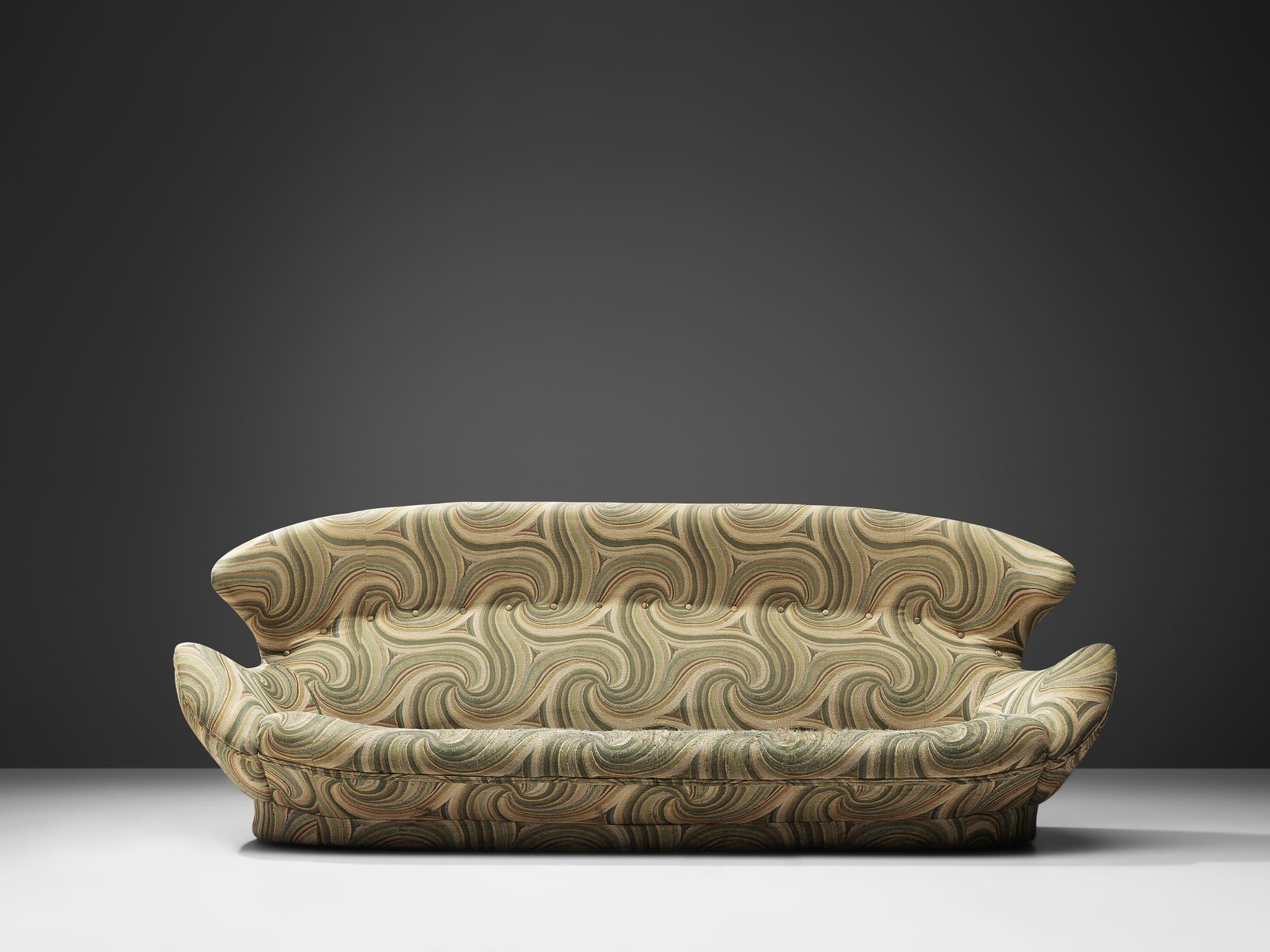 Two-seat sofa, green and cream patterned upholstery, Europe, 1970s.

Comfortable winged sofa with hypnotizing and decorative patterned upholstery. The rounded overall shape of the sofa, with the wings reaching towards the armrests, ensures that the