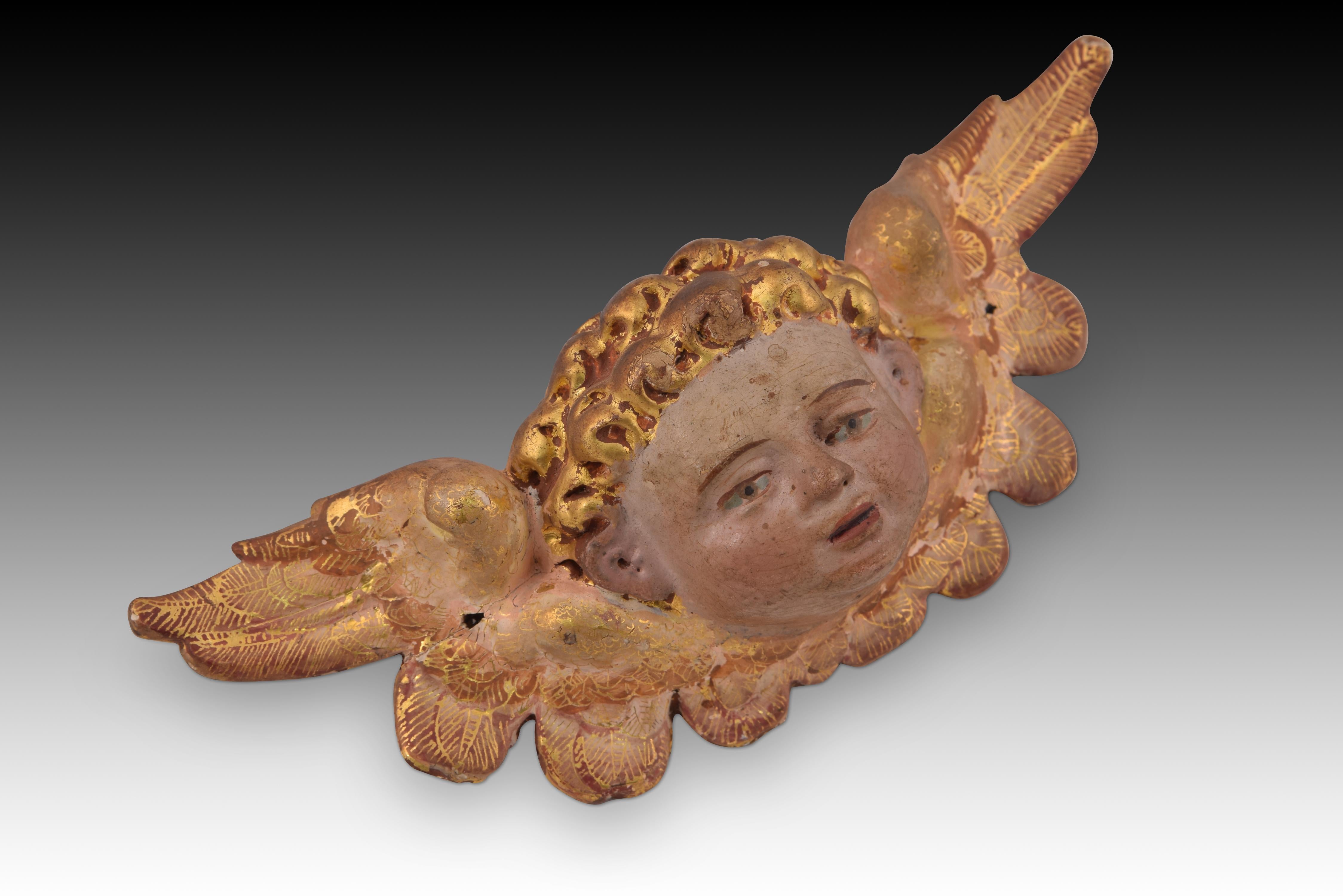 Winged angel head. Polychrome wood. Spanish school, 16th century. Carved and gilded wooden sculpture that shows a child's head with blonde, curly hair adorned with two wings. This type of sculpture of winged angels was very common throughout Europe