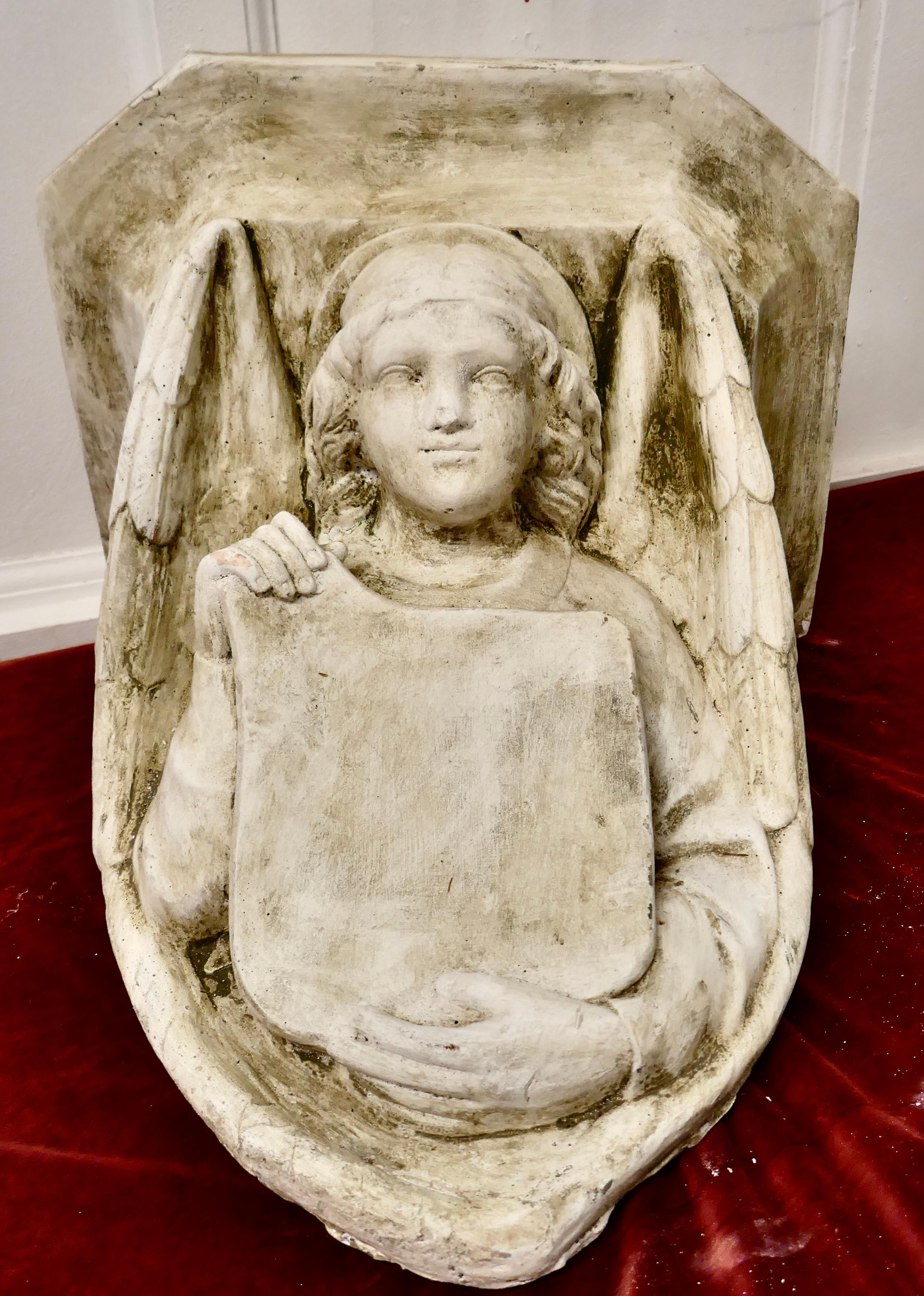 Winged angel, weathered wall bracket

This is a well weathered and heavy piece, it hangs by means of 2 loops on the back, the bracket is made in reconstituted stone with plaster like finish
It is in generally good condition with a weathered