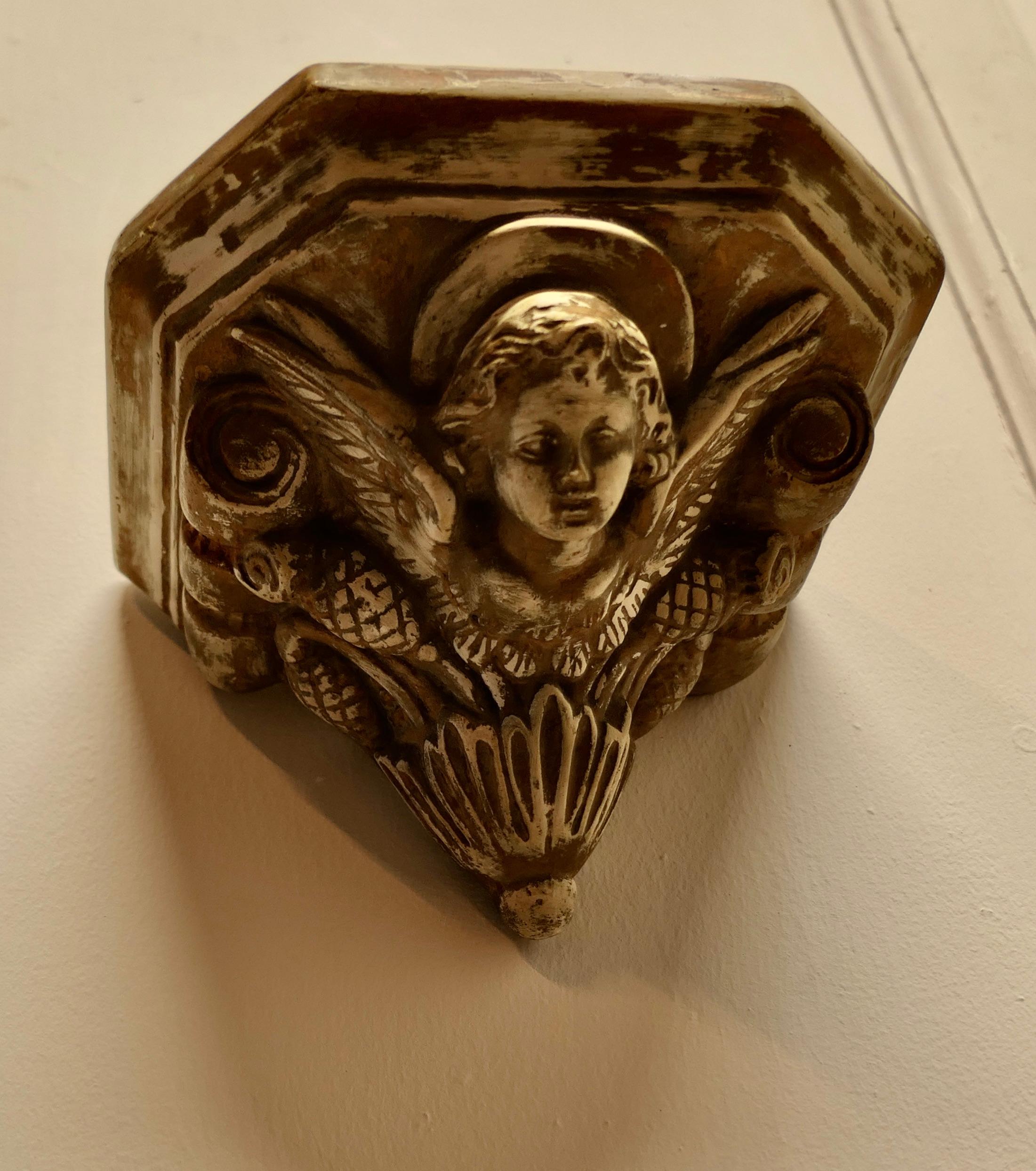 Winged Angel, Weathered Wall Bracket

This is a well weathered piece, the bracket is made in hard plaster with a very worn gilt finish
It is in generally good condition with a weathered finish 
The bracket is 5” high, 8” x 7 ” on top
VY132