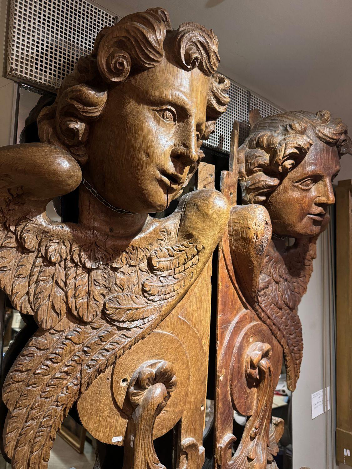 Paire de très grandes pièces de boiserie (2,22 mètres de haut) représentant des anges ailés dans la partie supérieure, surmontés de motifs en volutes et de guirlandes de fleurs descendantes.
Faisant probablement partie d'un buffet d'orgue, ou se