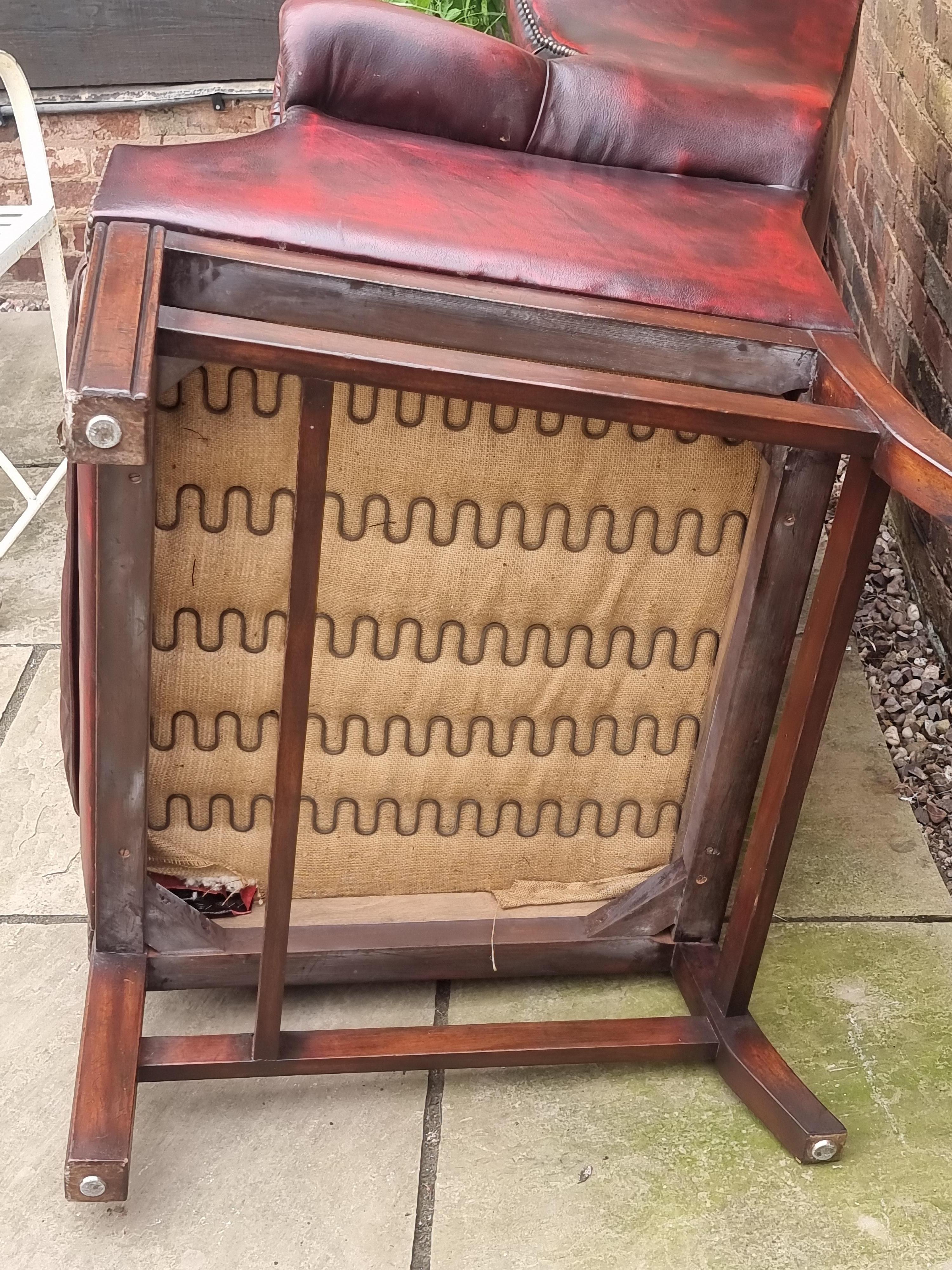 Winged armchair upholstered in deep buttoned red leather, English 1930 For Sale 5