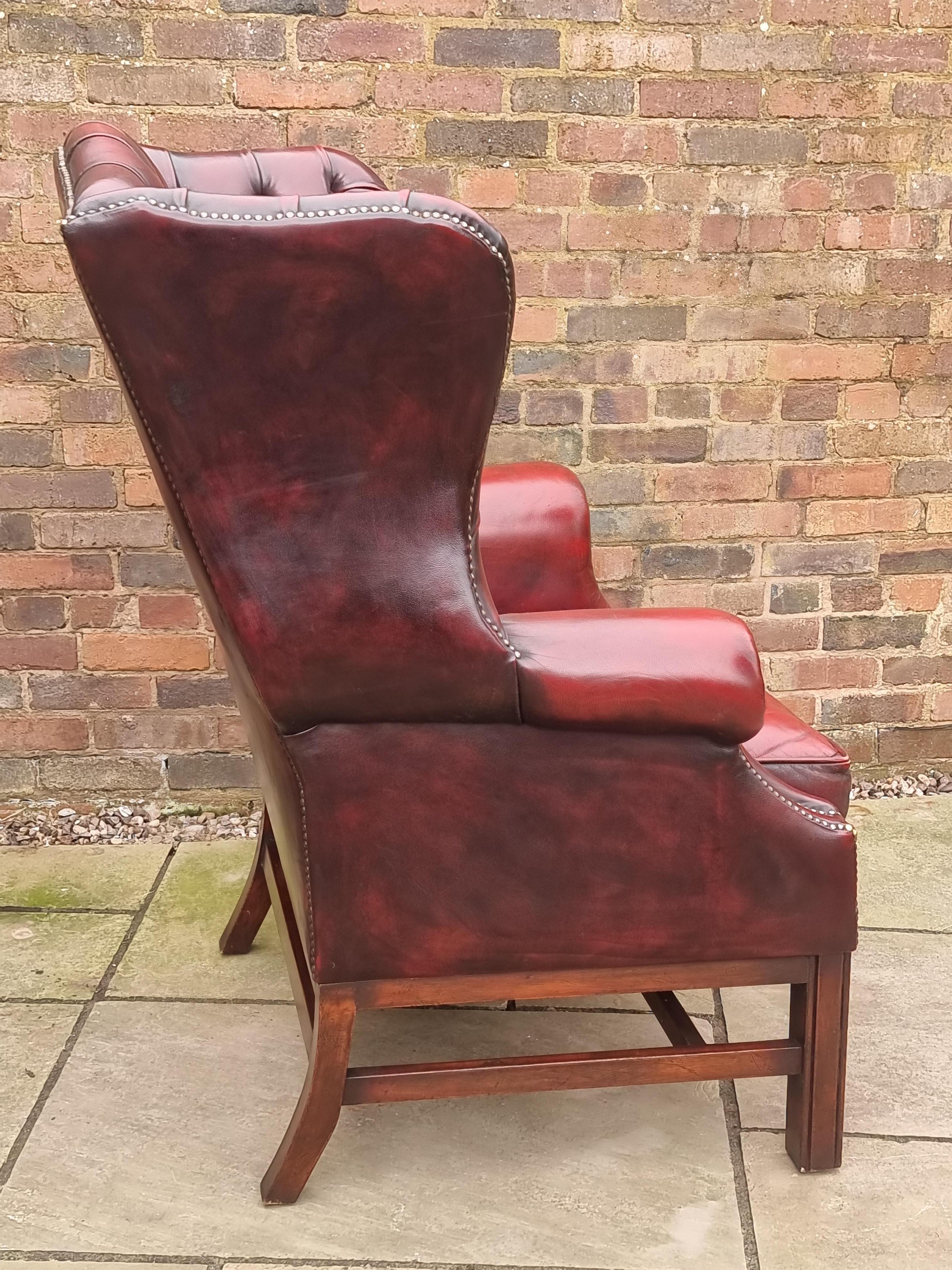 Winged armchair upholstered in deep buttoned red leather, English 1930 For Sale 9